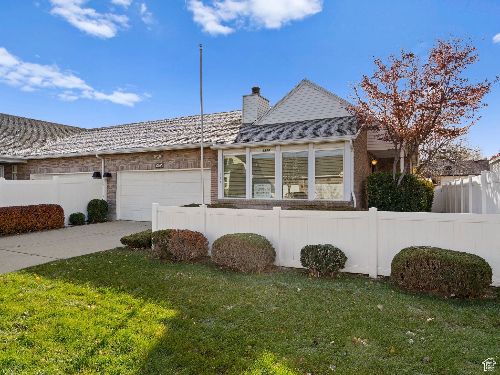 Ranch-style home featuring a garage and a front lawn