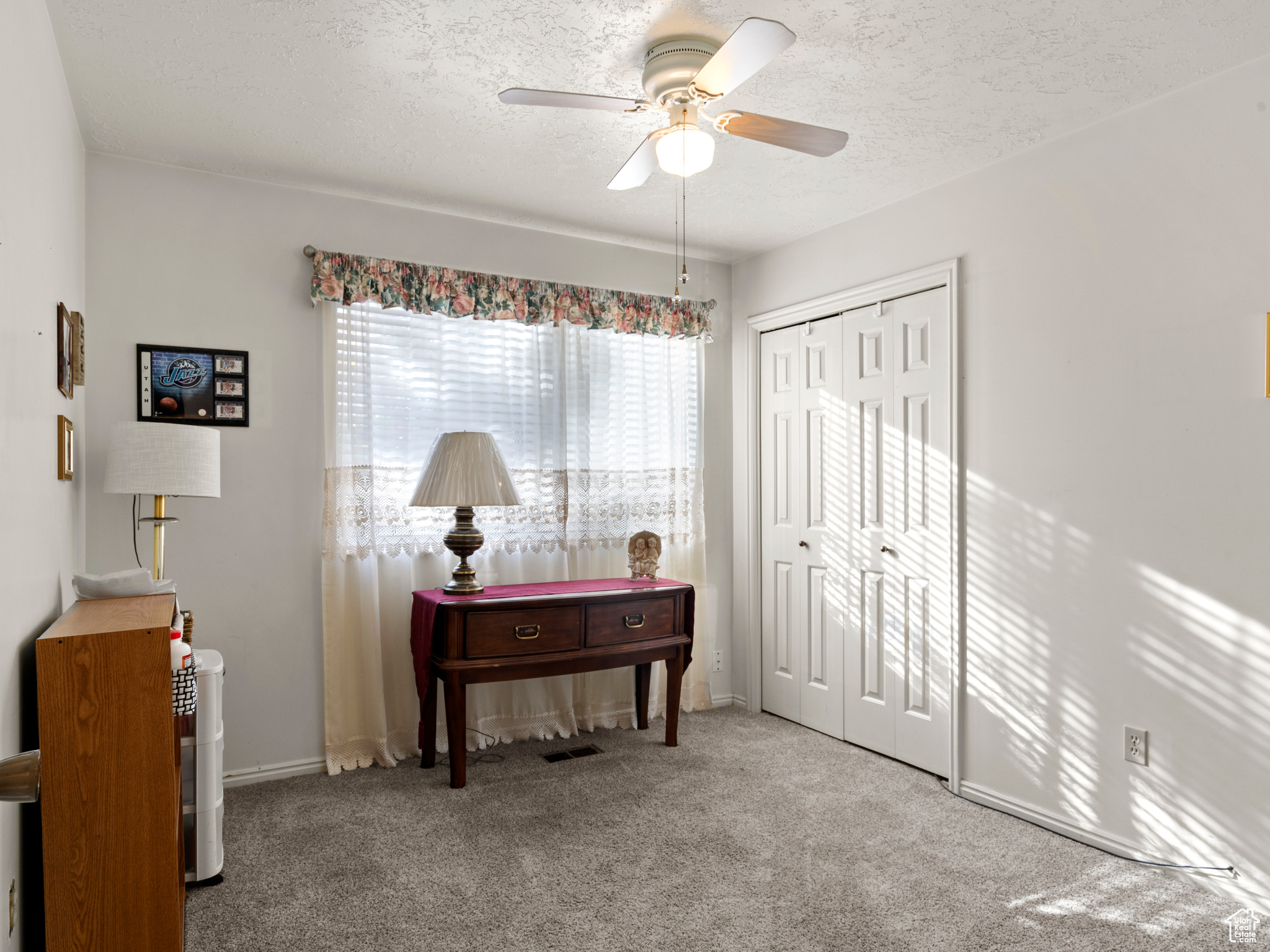 Miscellaneous room featuring a textured ceiling, carpet floors, and ceiling fan