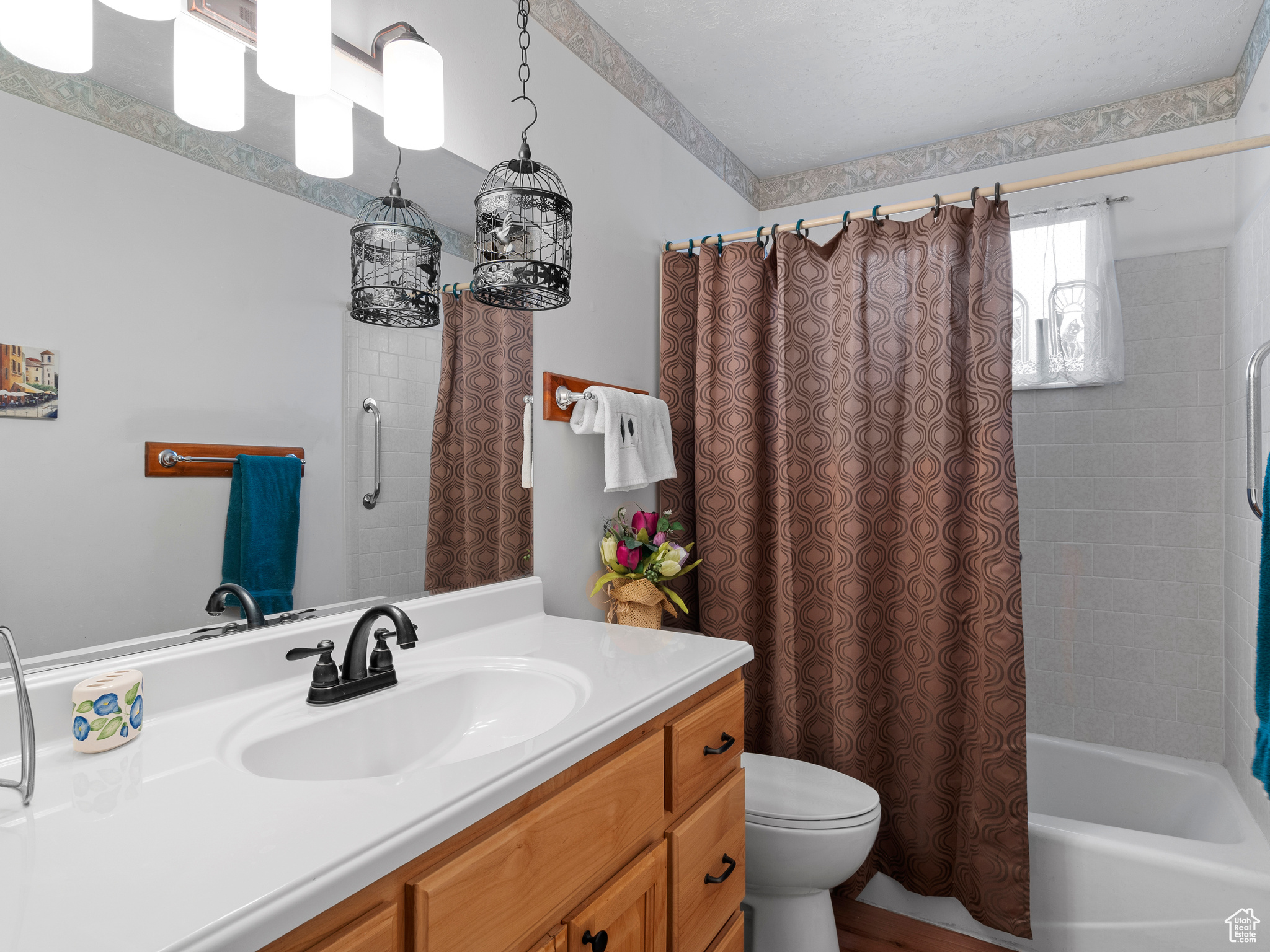 Full bathroom featuring shower / bathtub combination with curtain, vanity, and toilet