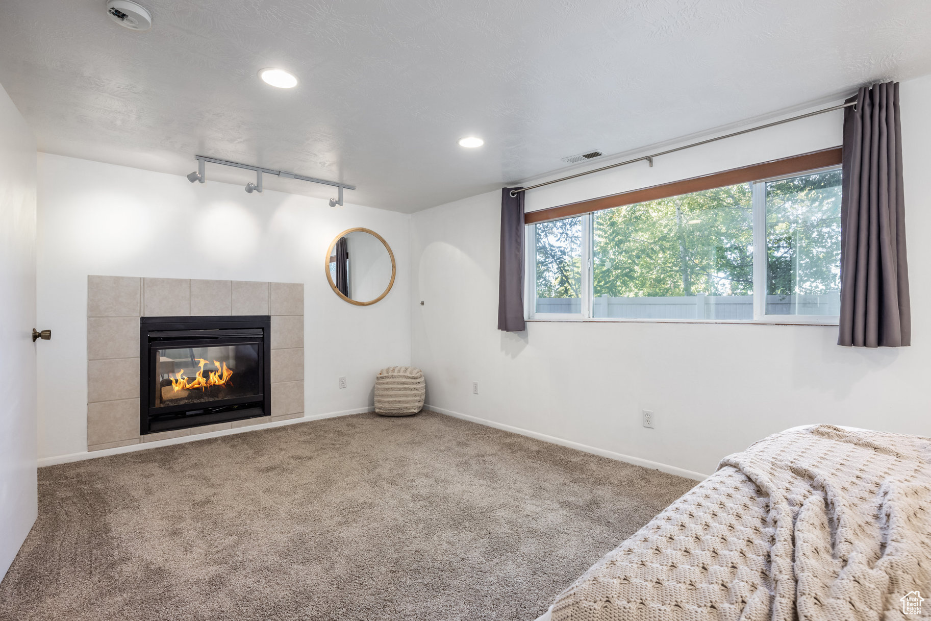 Unfurnished room with carpet flooring and track lighting