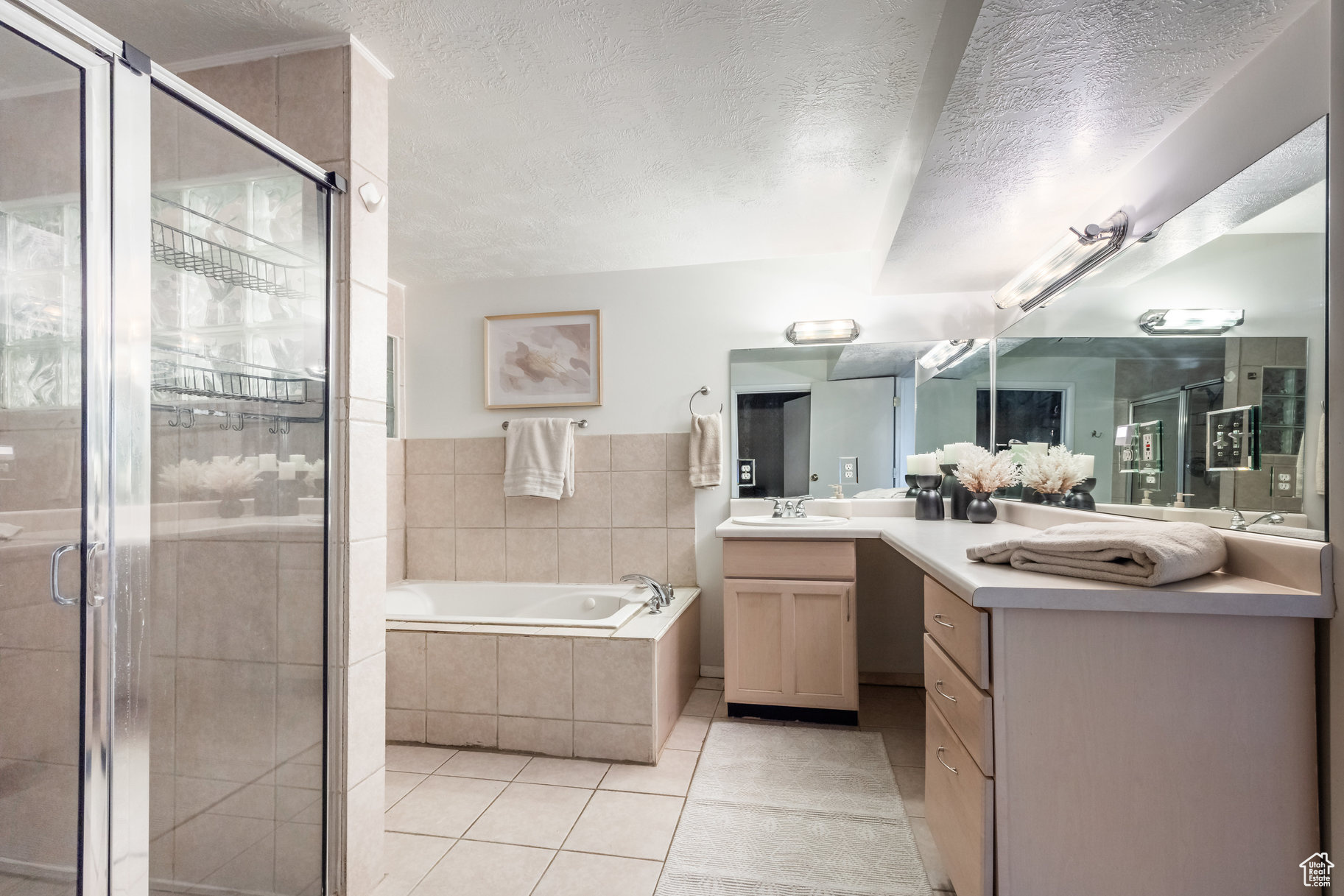 Bathroom featuring tile patterned floors, separate shower and tub, and a textured ceiling