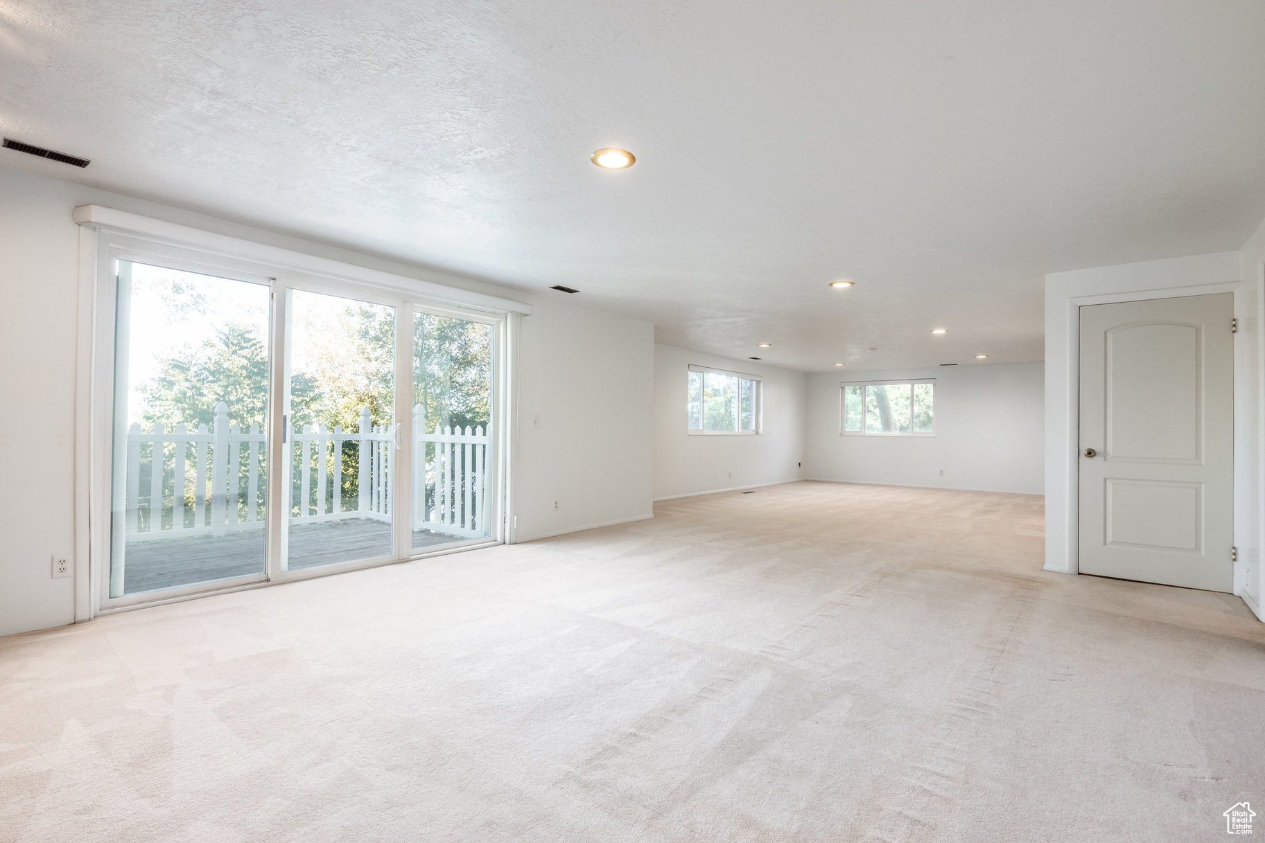 Unfurnished room with light colored carpet and a textured ceiling