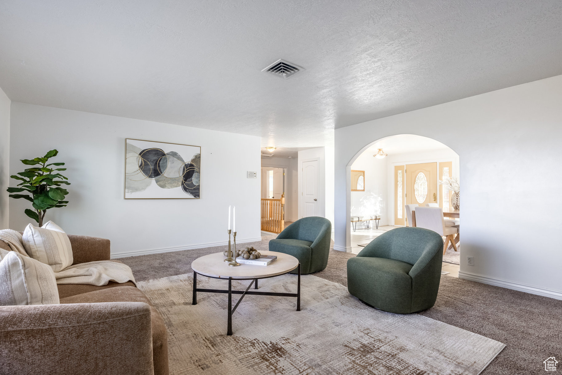 Carpeted living room featuring a textured ceiling