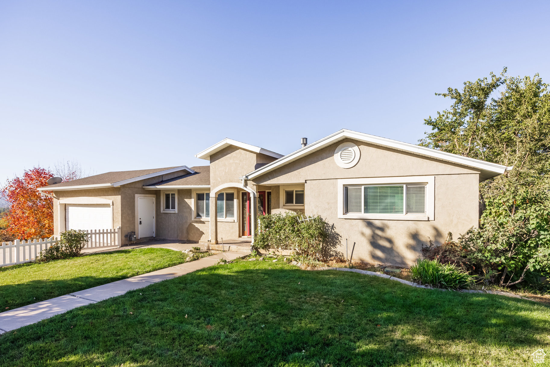 Single story home with a garage and a front lawn