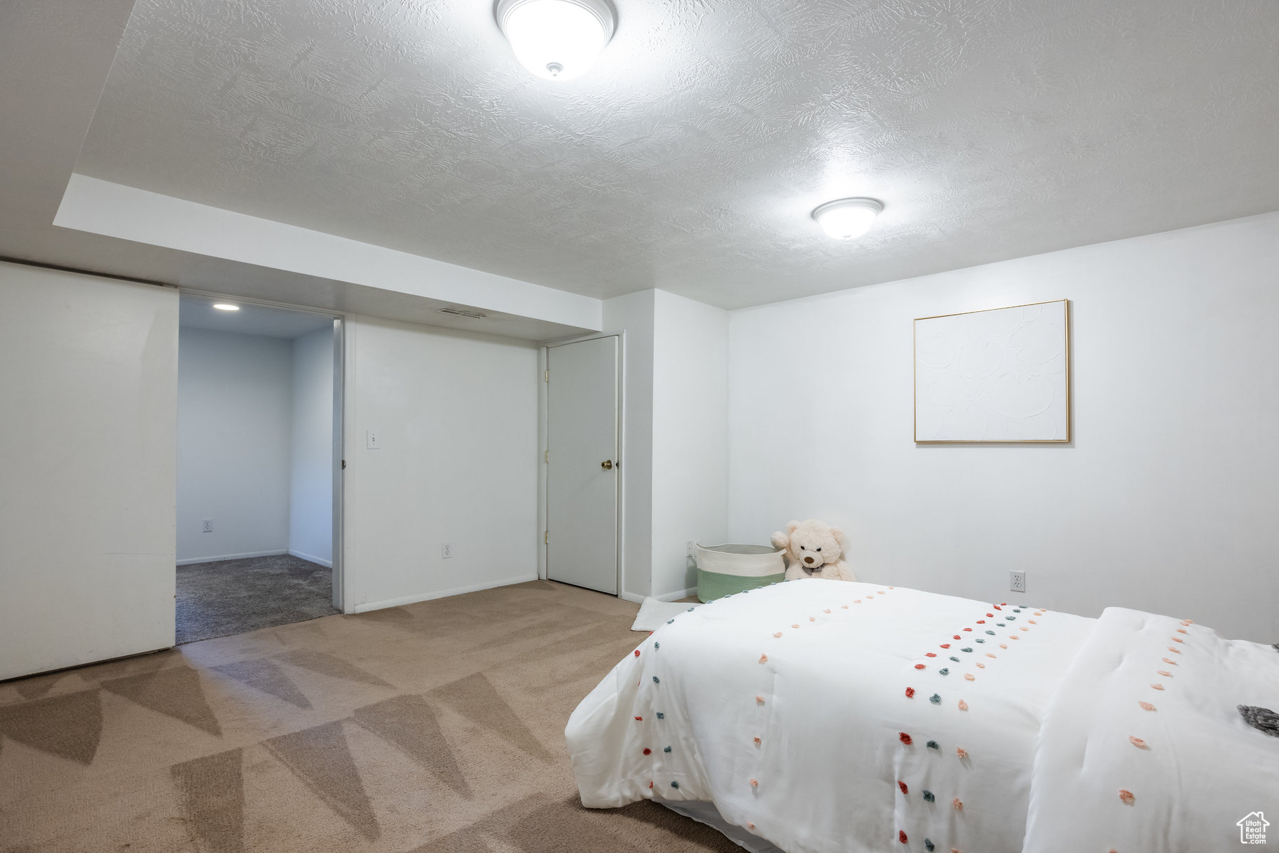 Bedroom with light carpet and a textured ceiling