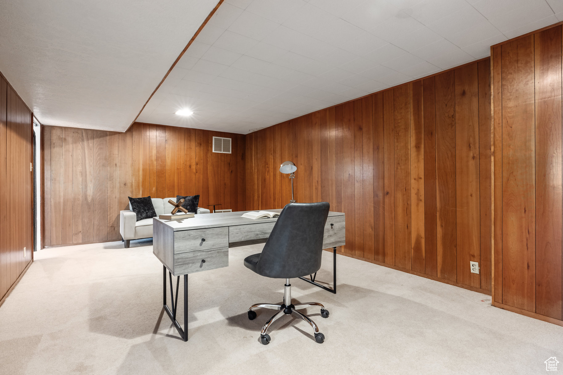 Carpeted office space with wood walls