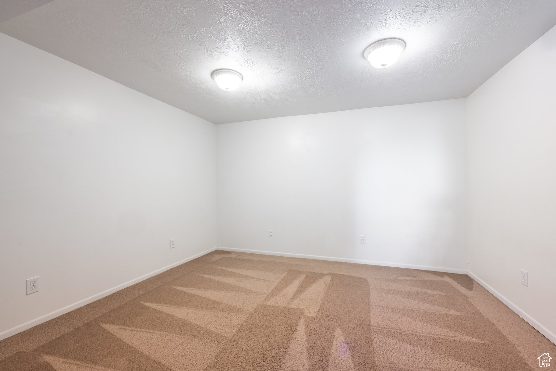 Unfurnished room featuring carpet floors and a textured ceiling