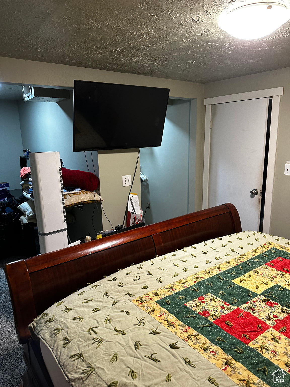 Carpeted bedroom featuring a closet and a textured ceiling