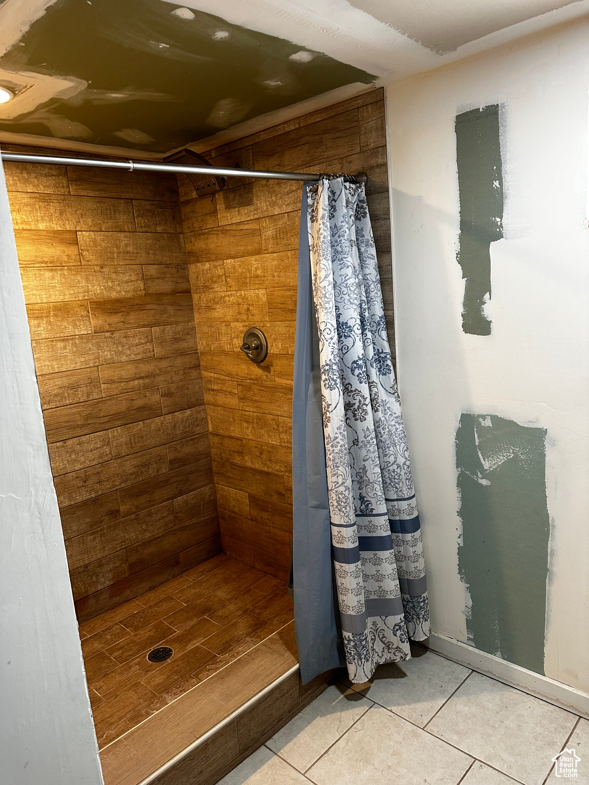 Bathroom featuring a shower with shower curtain, wood-type flooring, and wood walls