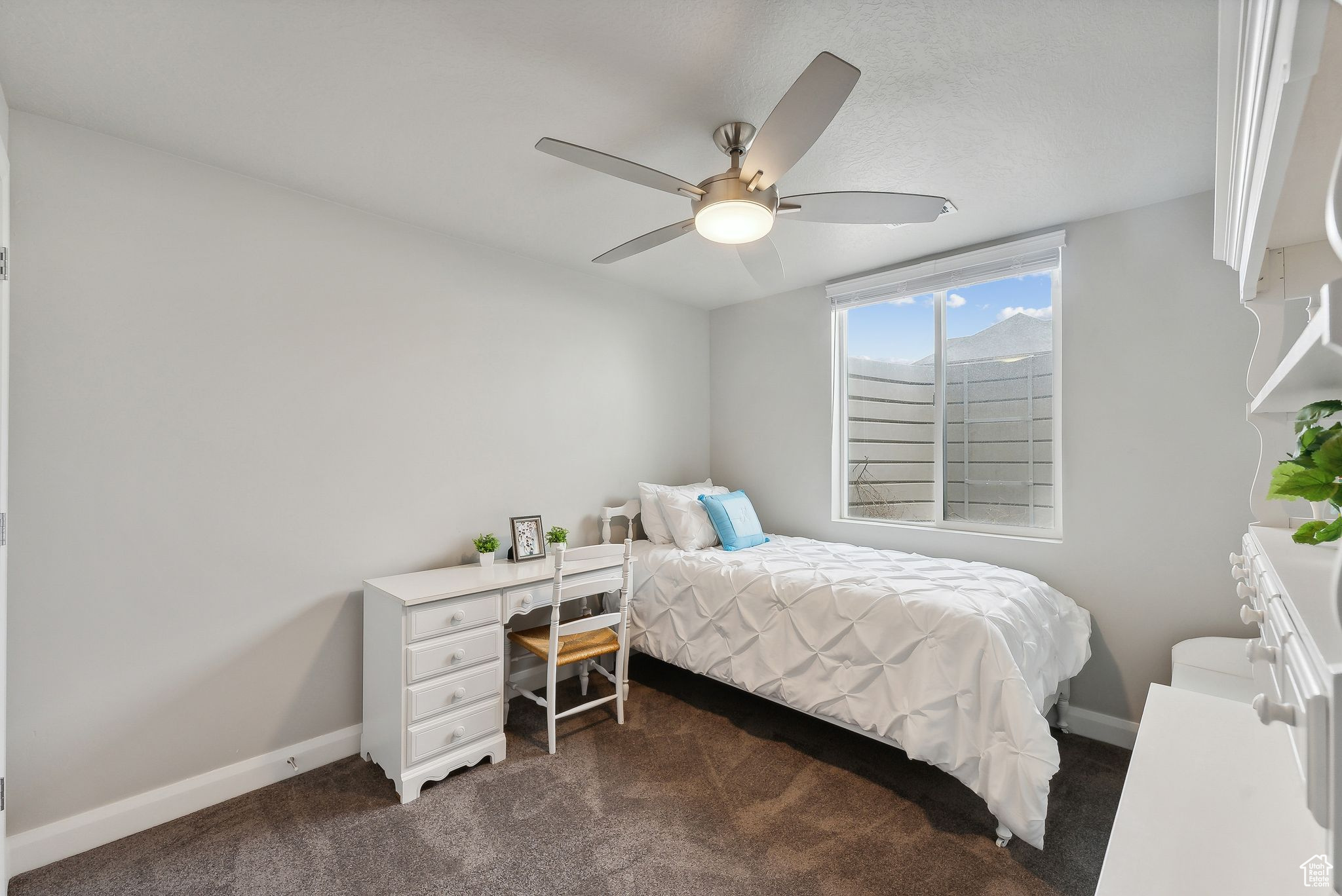 Carpeted bedroom featuring ceiling fan