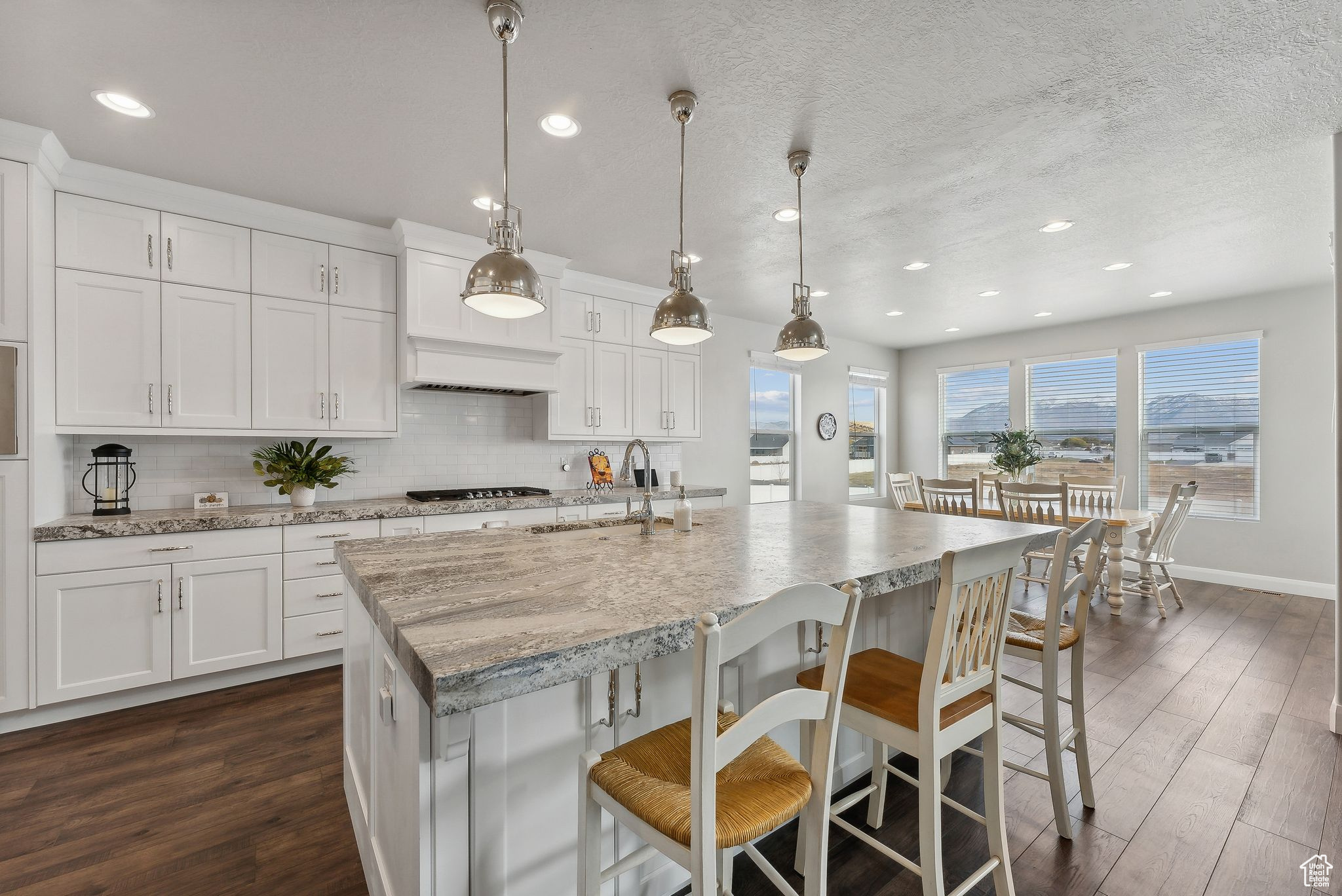 Kitchen featuring white cabinetry, sink, hanging light fixtures, and dark hardwood / wood-style floors