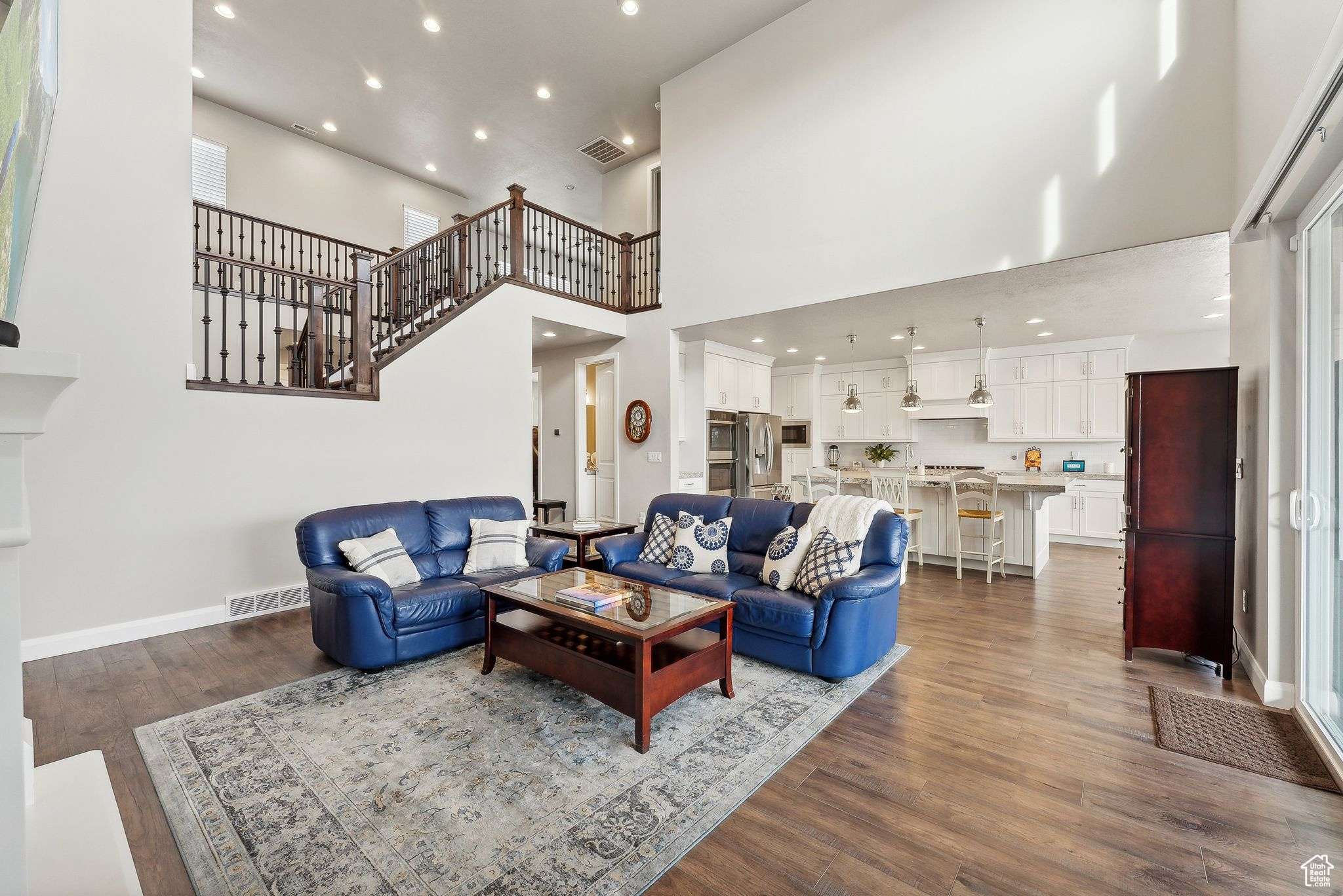 Living room with dark hardwood / wood-style flooring and a high ceiling