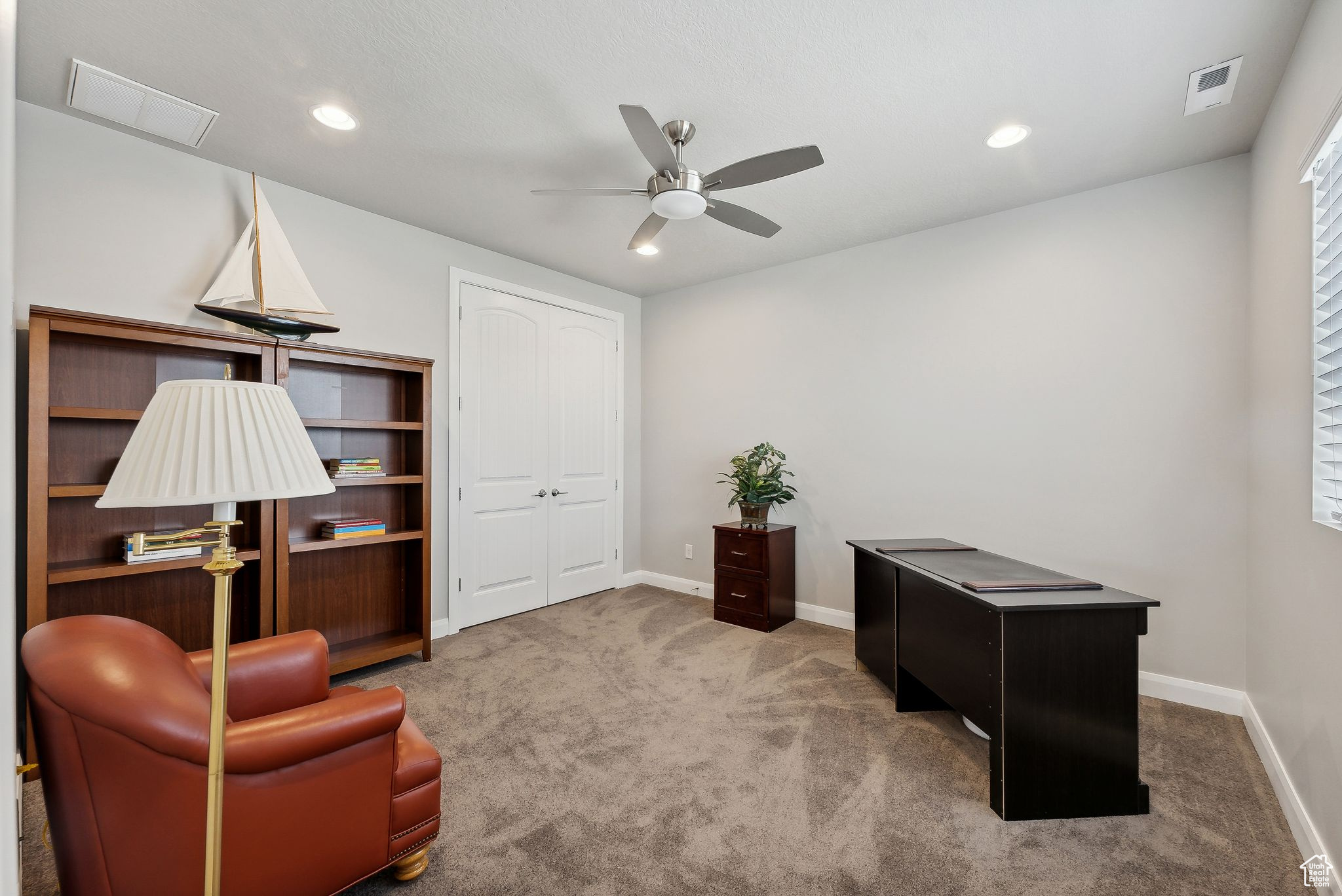 Home office featuring carpet flooring and ceiling fan