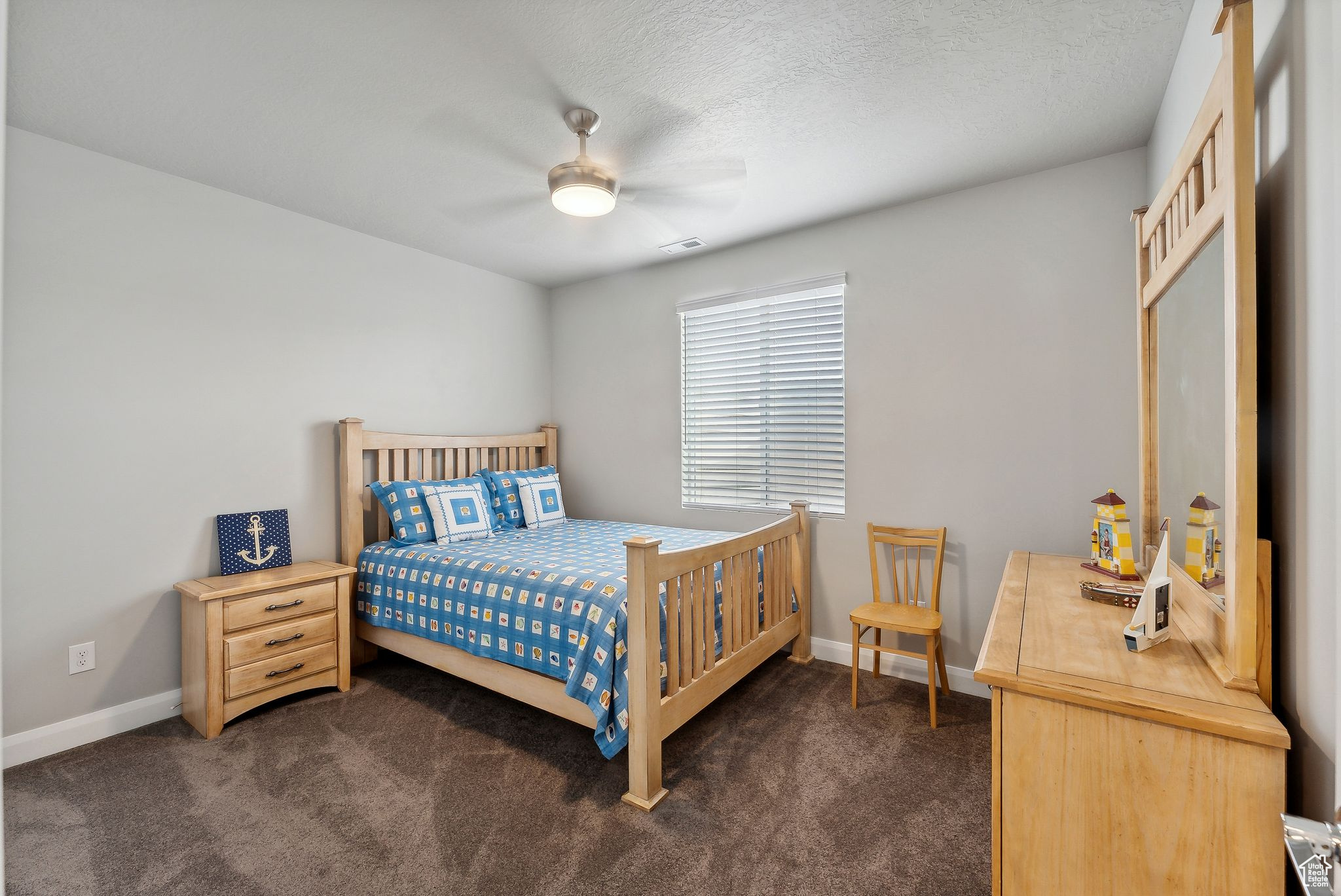 Bedroom featuring ceiling fan, a textured ceiling, and dark colored carpet