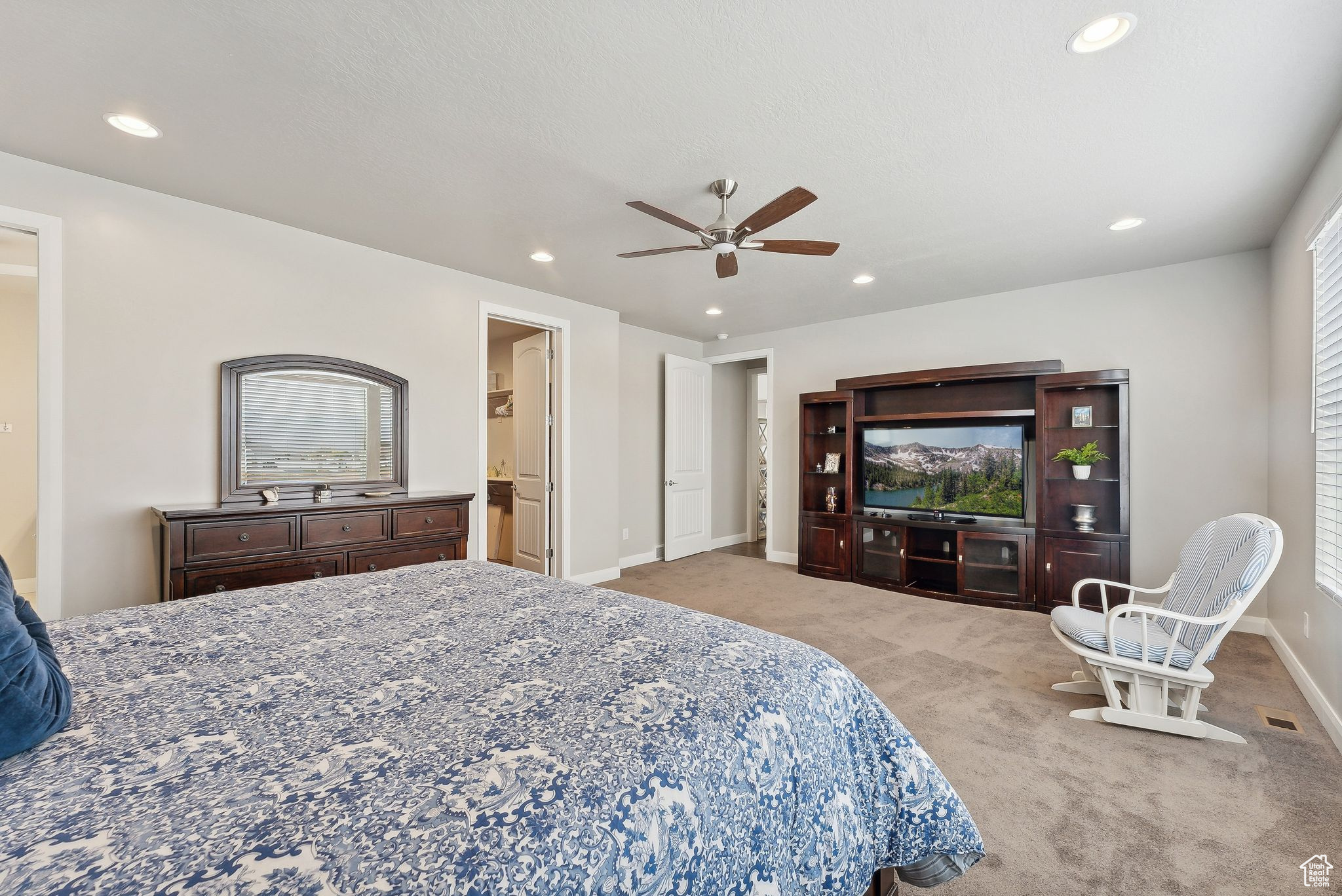 Bedroom with ceiling fan and light colored carpet