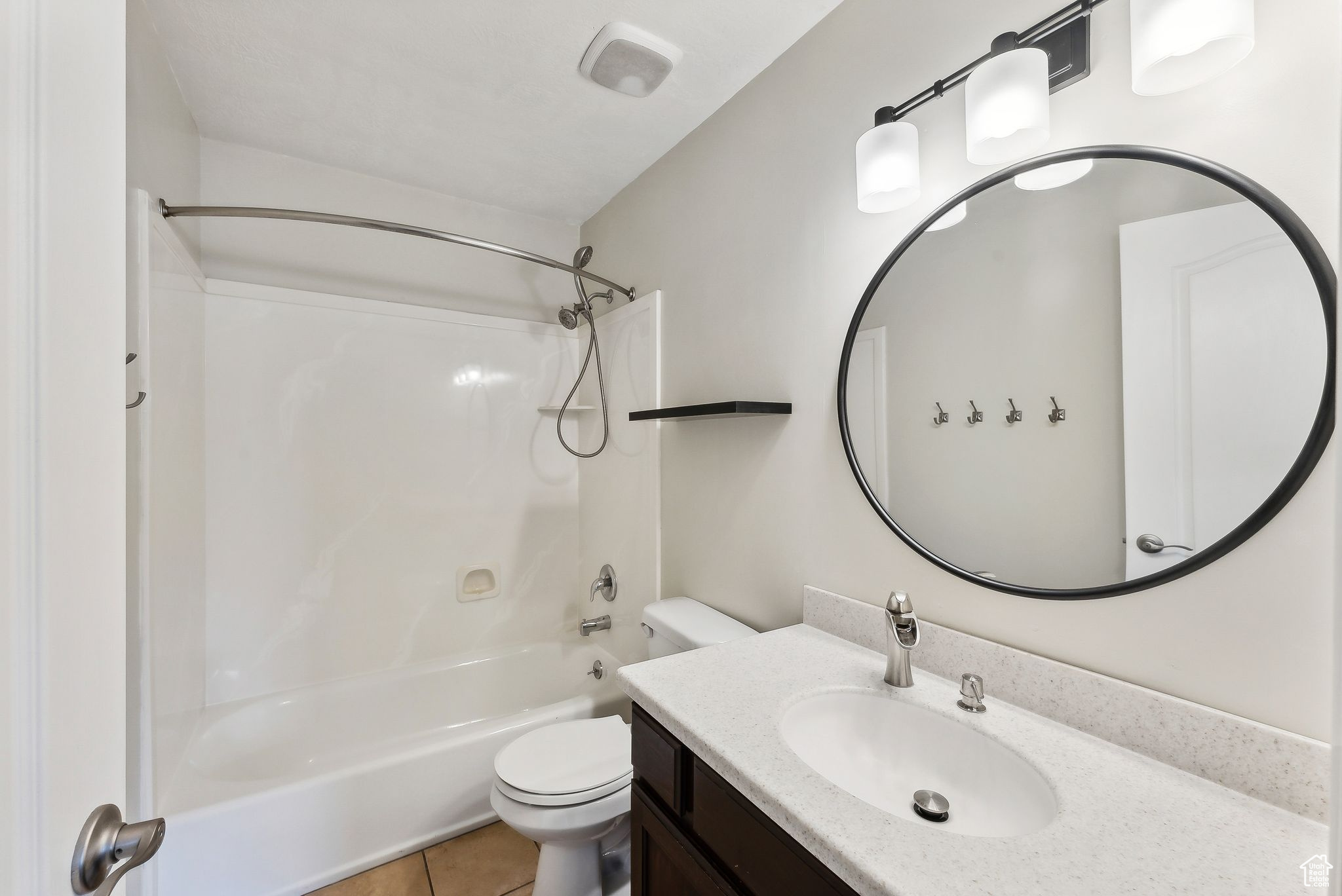 Full bathroom with tile patterned flooring, vanity, toilet, and shower / tub combination