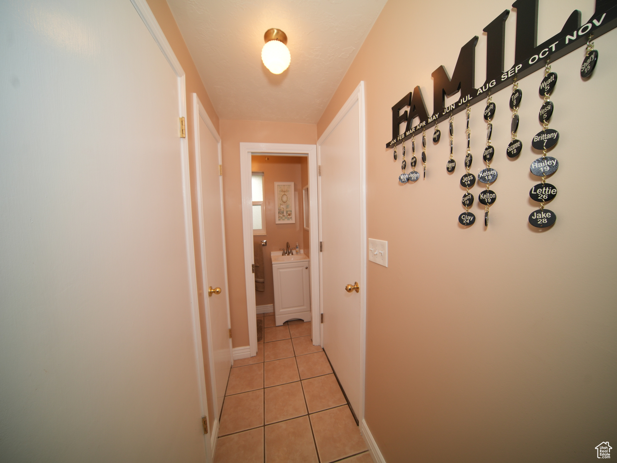 Hall featuring light tile patterned floors and sink