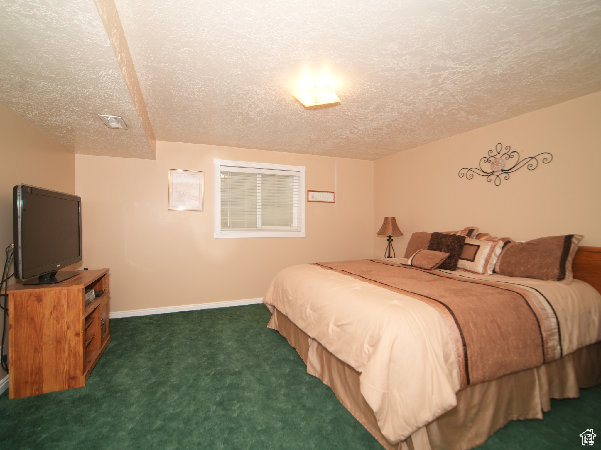 Bedroom featuring a textured ceiling and dark carpet