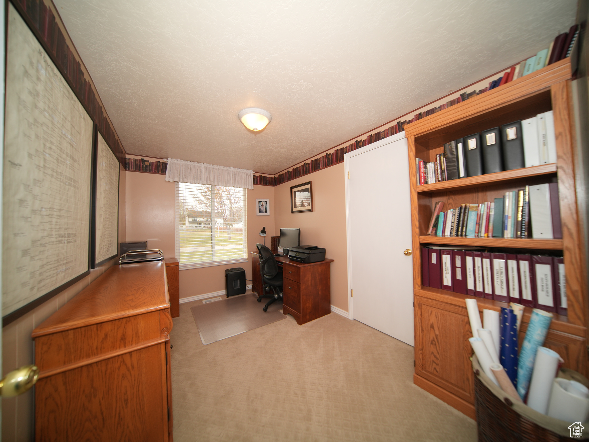 Home office featuring light carpet and a textured ceiling