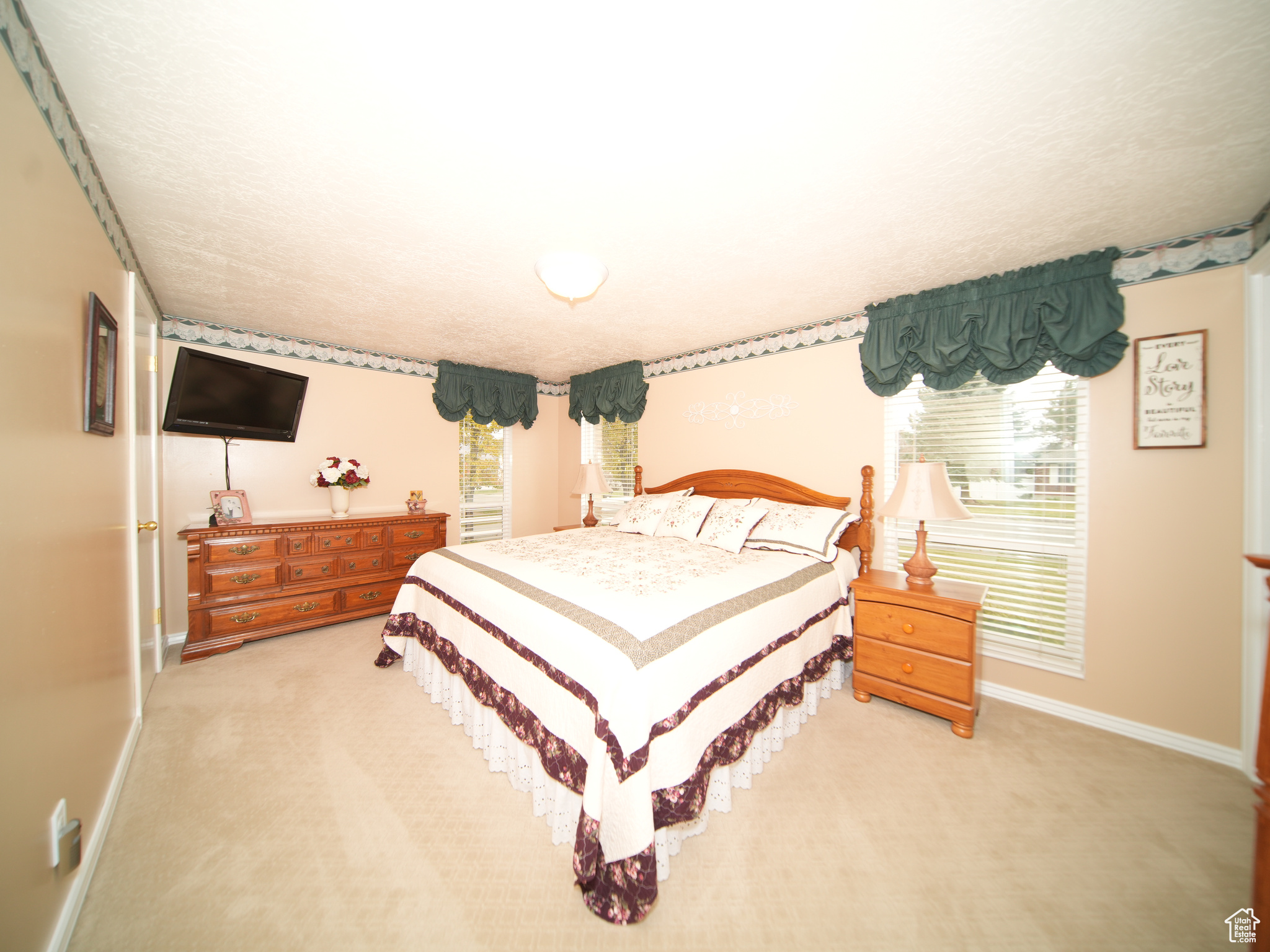 Carpeted bedroom featuring multiple windows