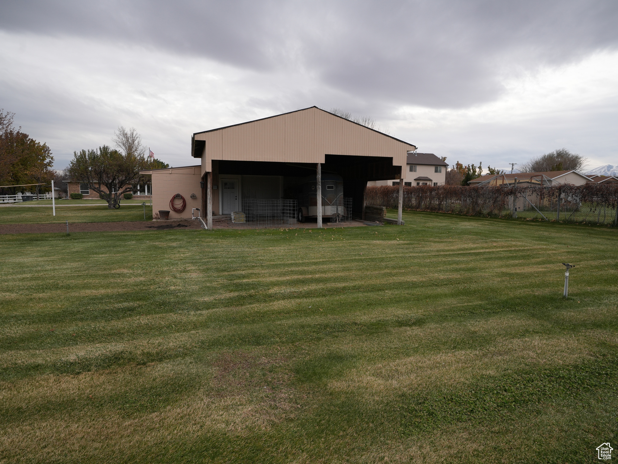 Exterior space featuring a lawn and exterior covered storage behind barn