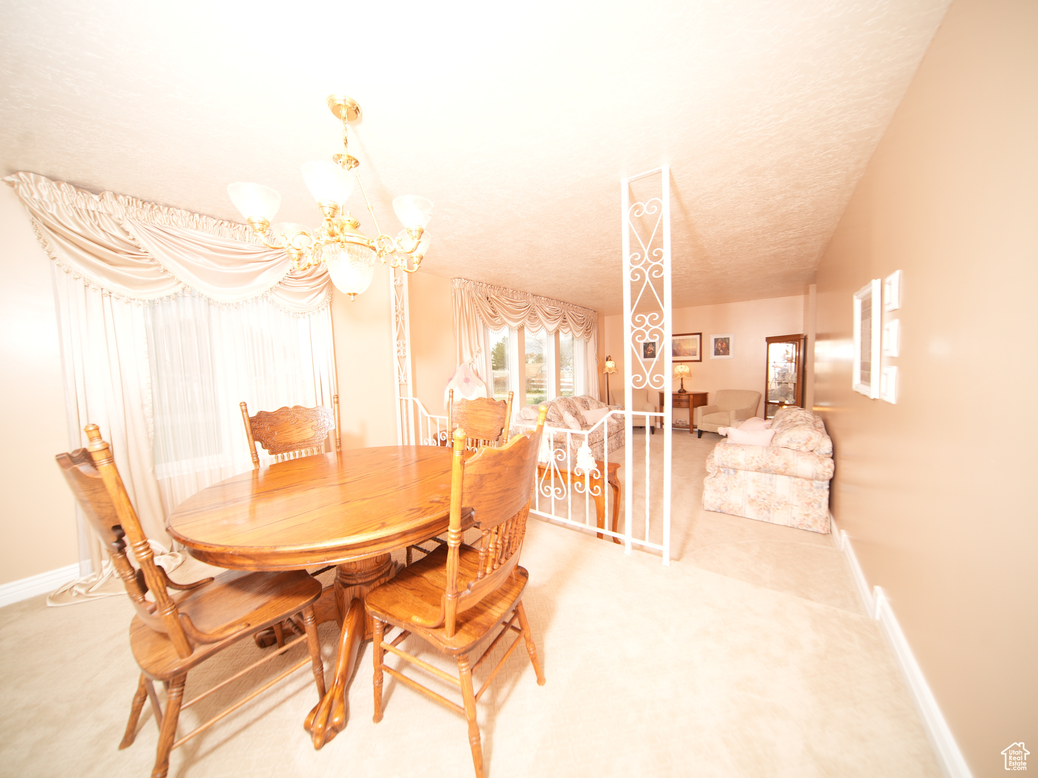 Dining area featuring carpet floors, a textured ceiling, and an inviting chandelier