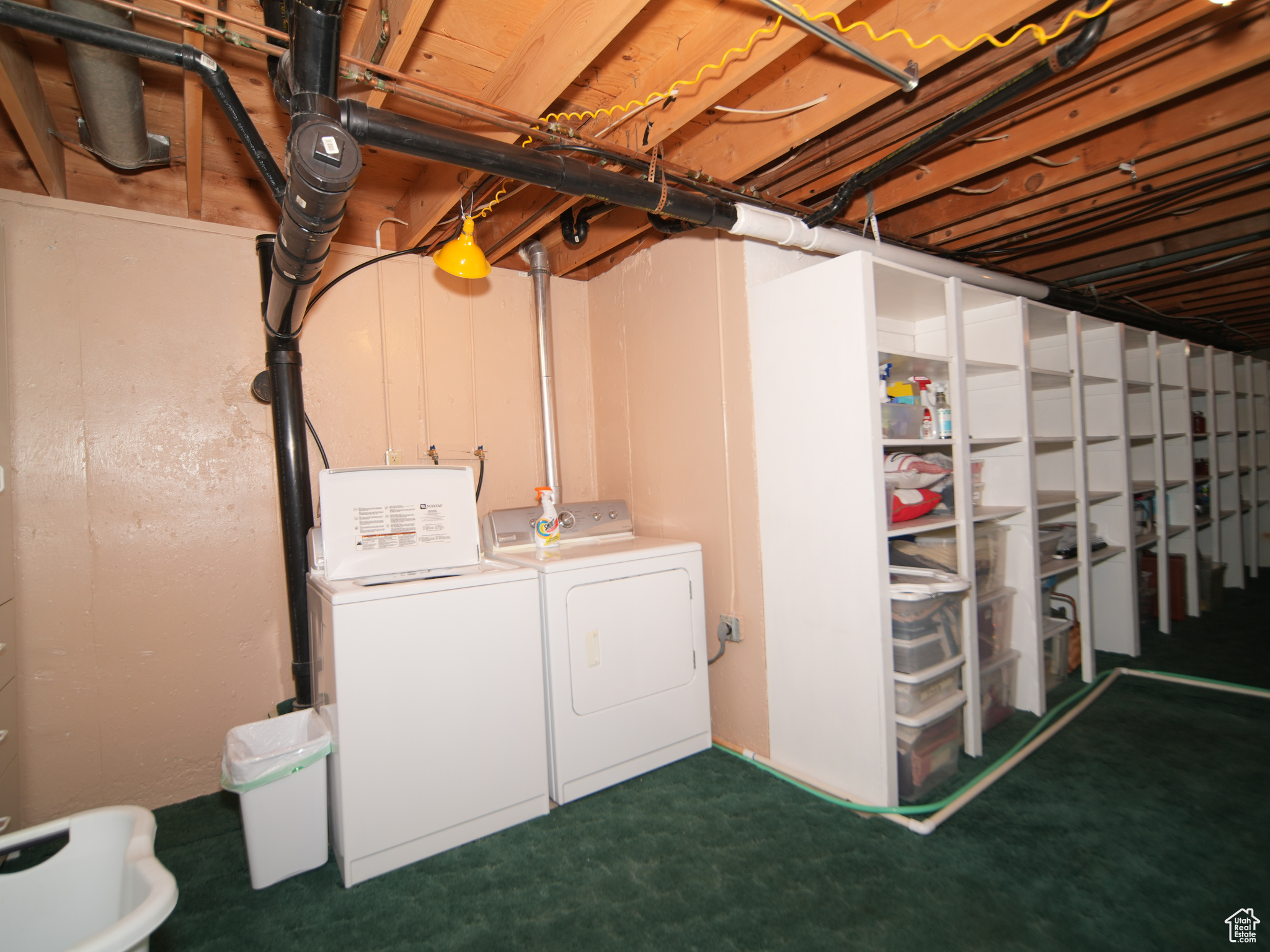 Basement with washing machine and clothes dryer and dark colored carpet