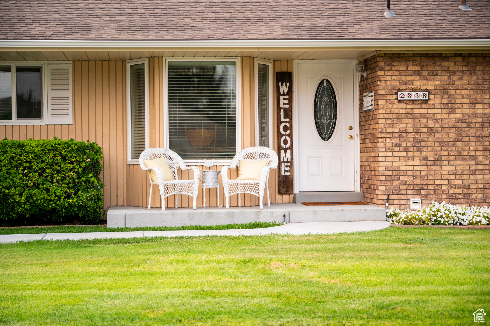 Property entrance featuring covered porch and a yard