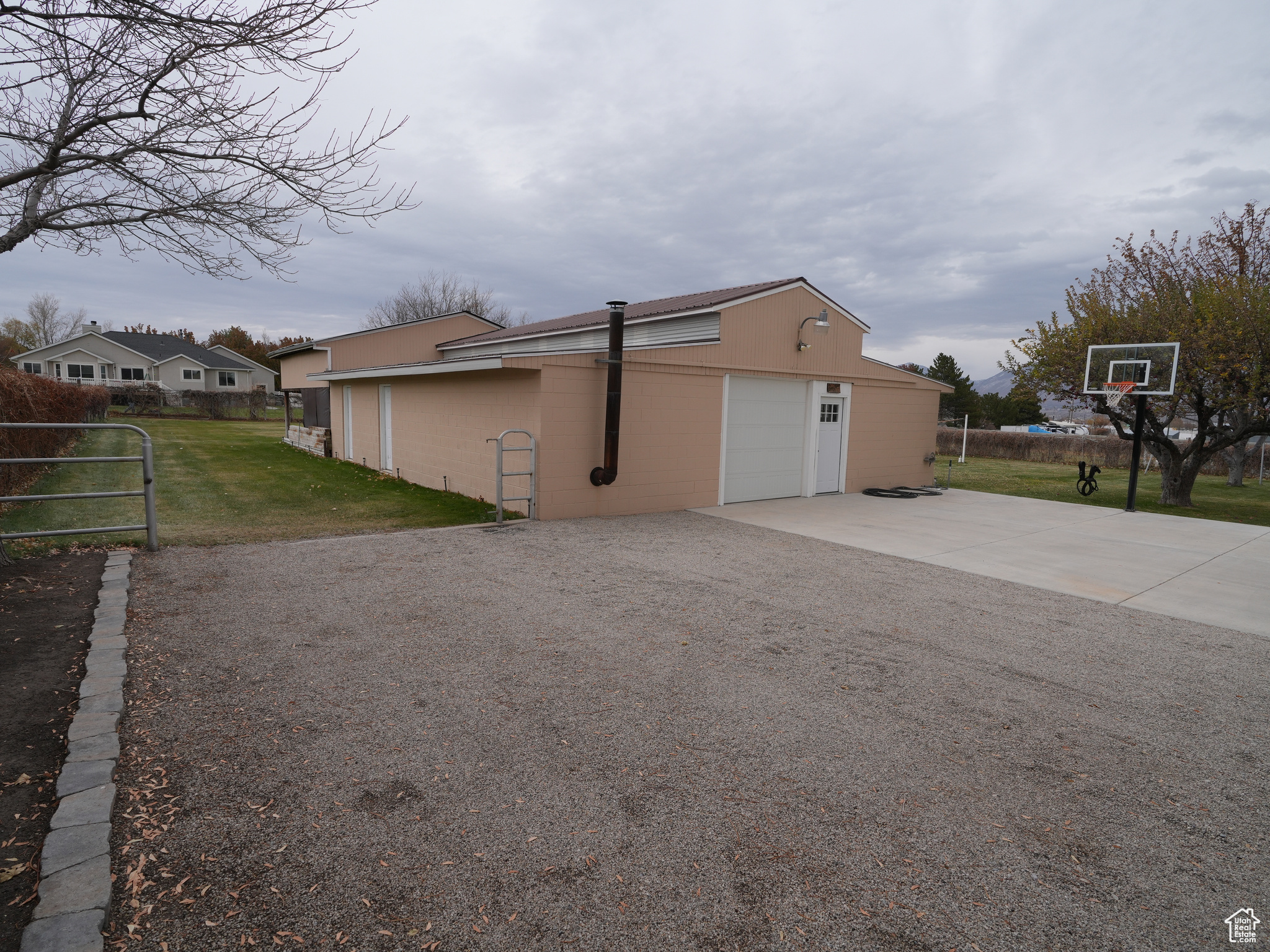 View of property exterior with a yard and basketball standard