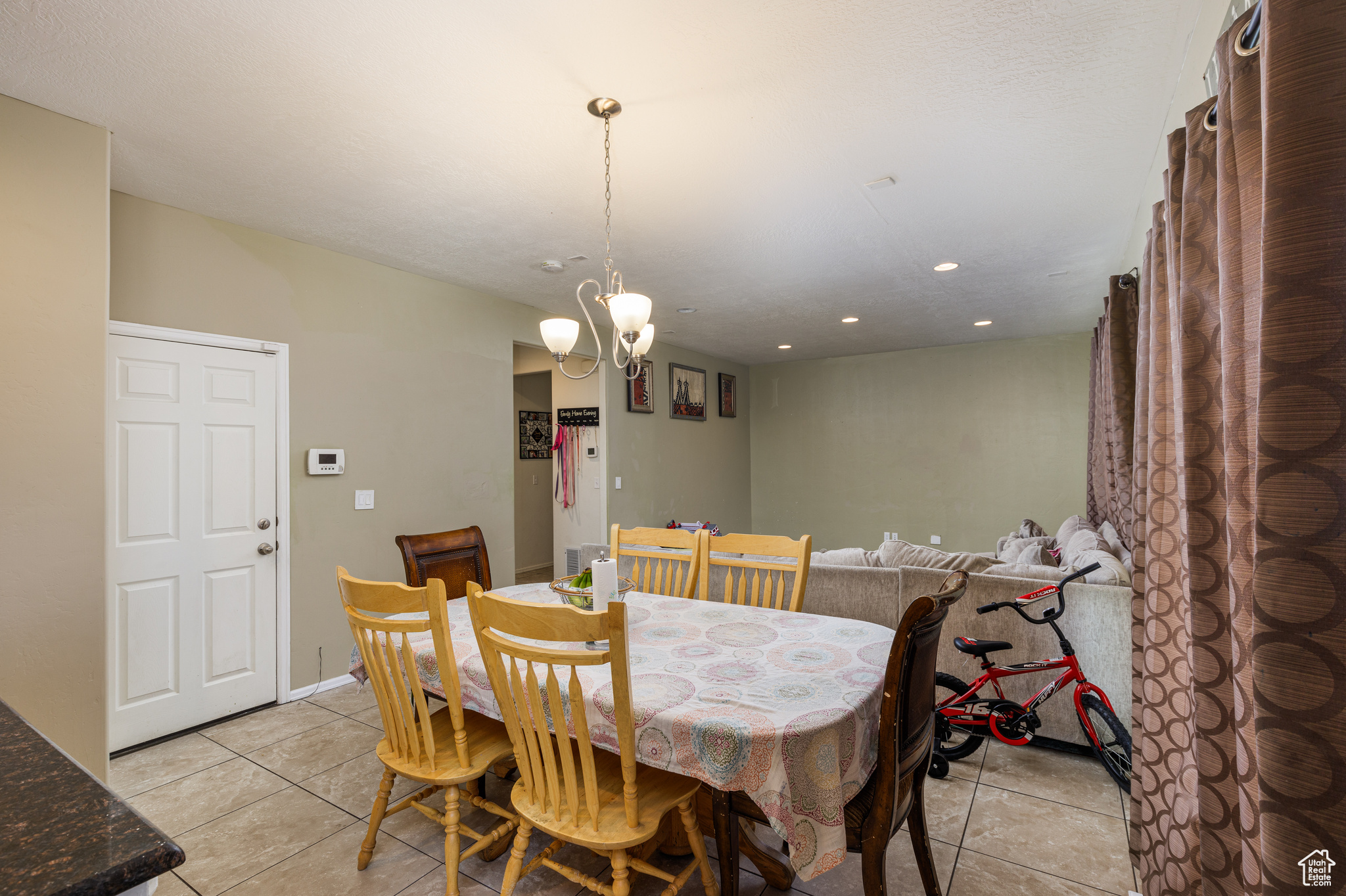 Tiled dining area featuring a chandelier