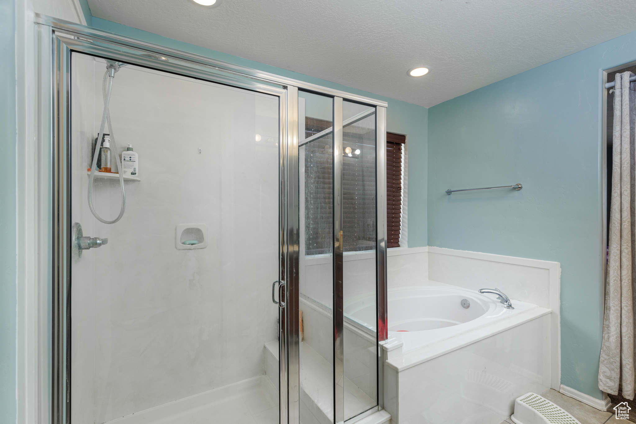 Bathroom with independent shower and bath and a textured ceiling