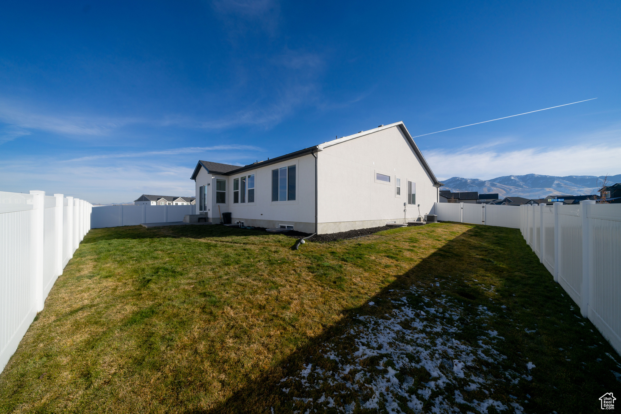 View of side of home featuring a lawn and a mountain view