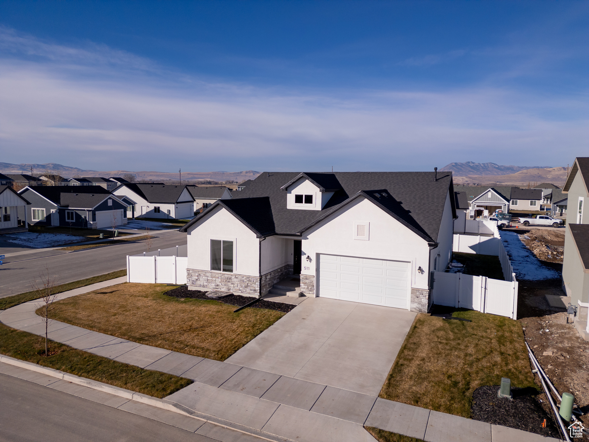 View of front of home featuring a mountain view, a garage, and a front lawn