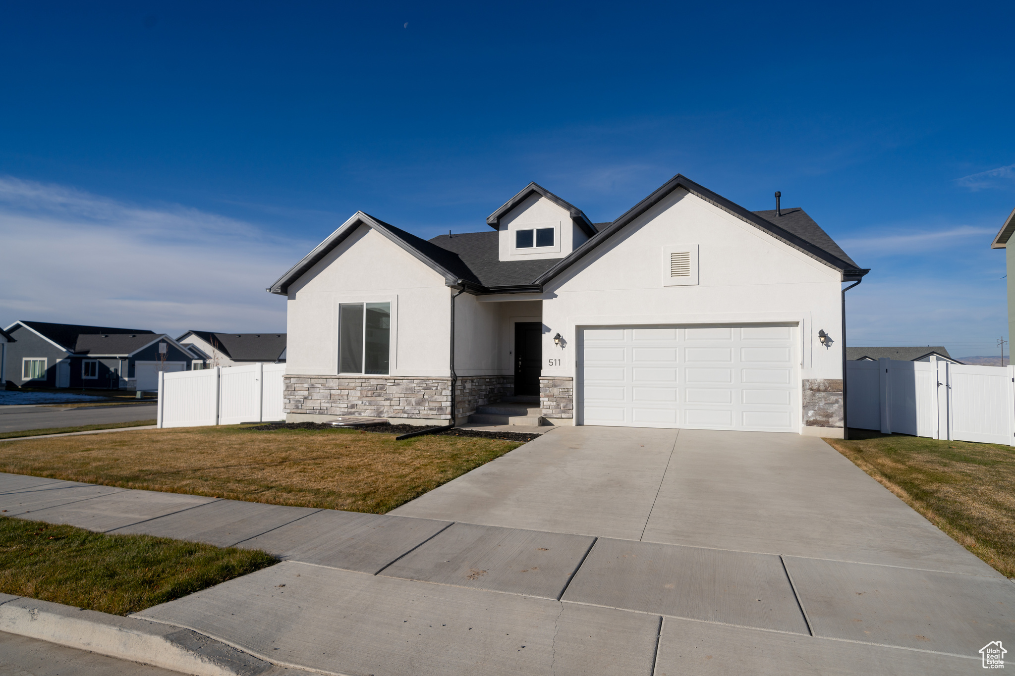 View of front of property featuring a garage and a front lawn