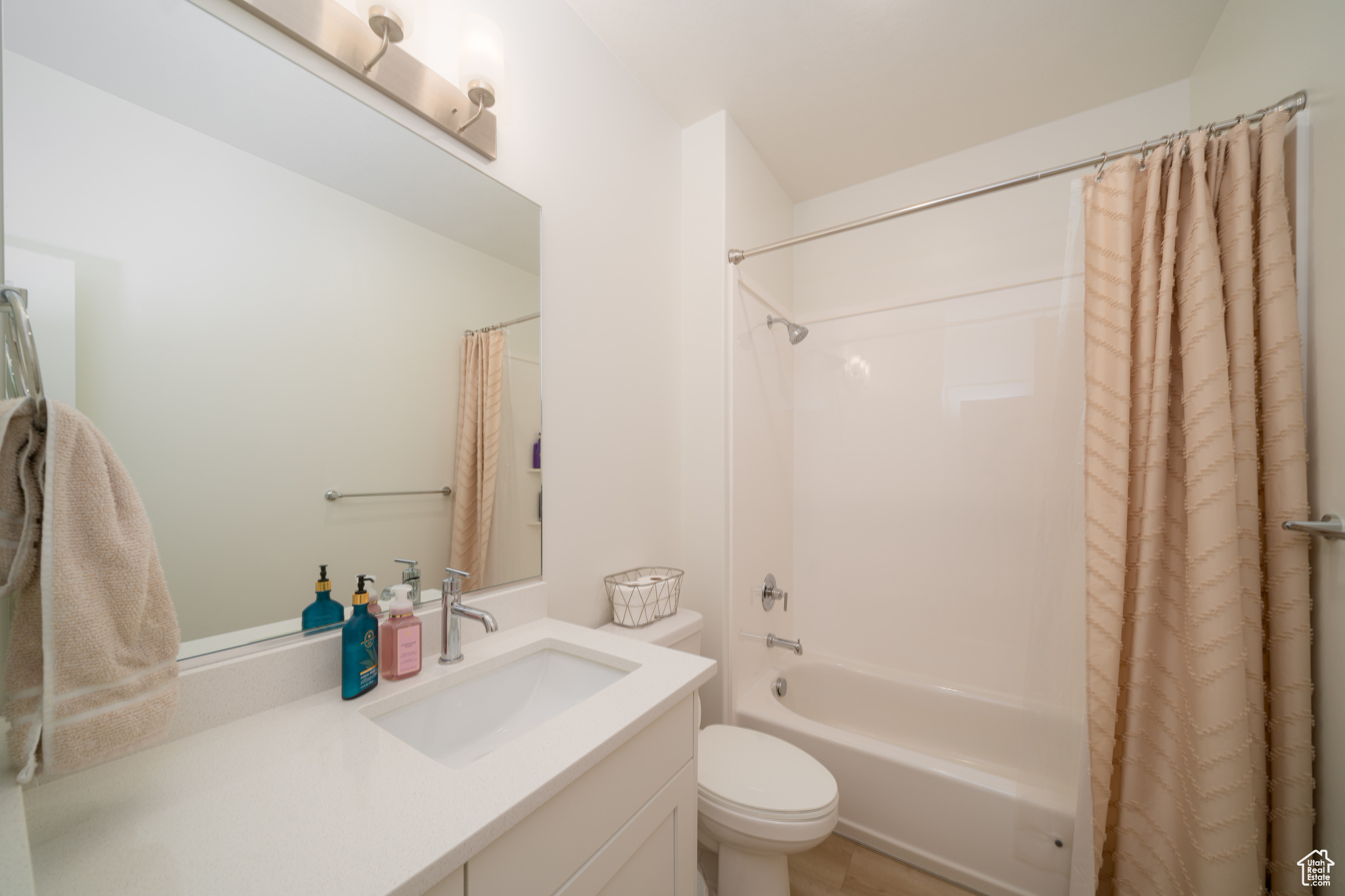 Full bathroom with vanity, toilet, and shower / bathtub combination with curtain