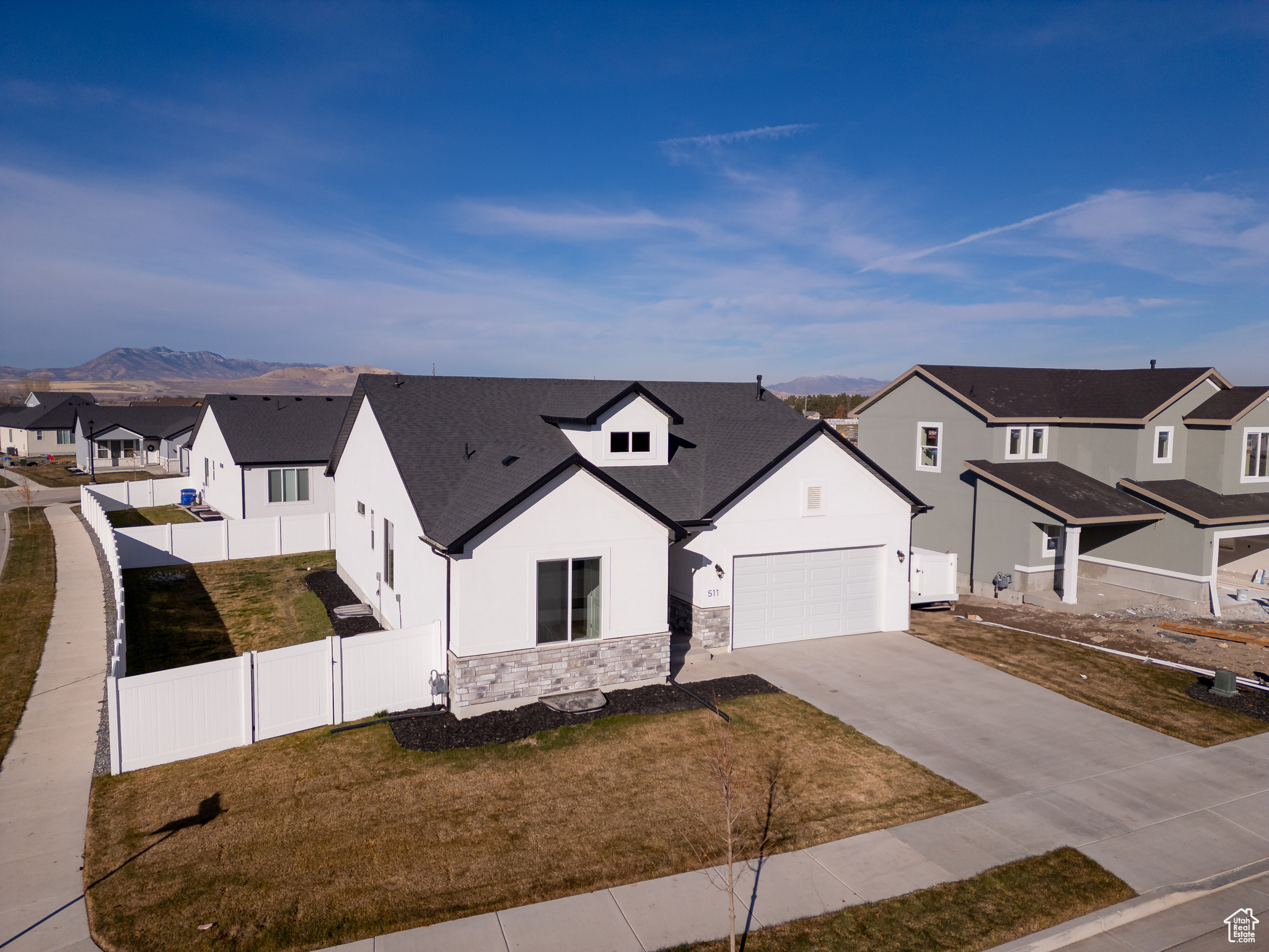 View of front of home featuring a mountain view, a front lawn, and a garage