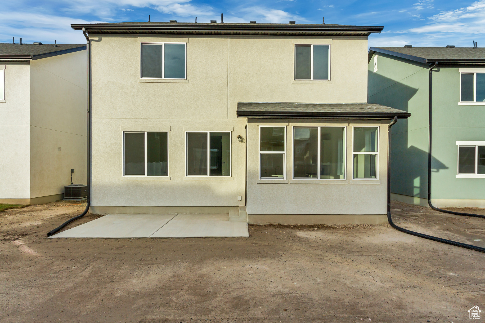 Rear view of property featuring a patio area and central AC