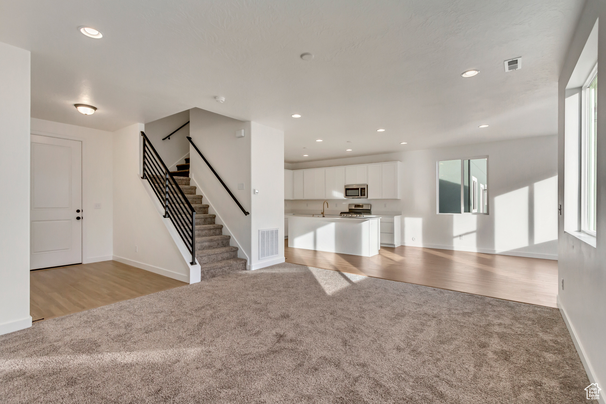 Unfurnished living room with sink and light hardwood / wood-style flooring