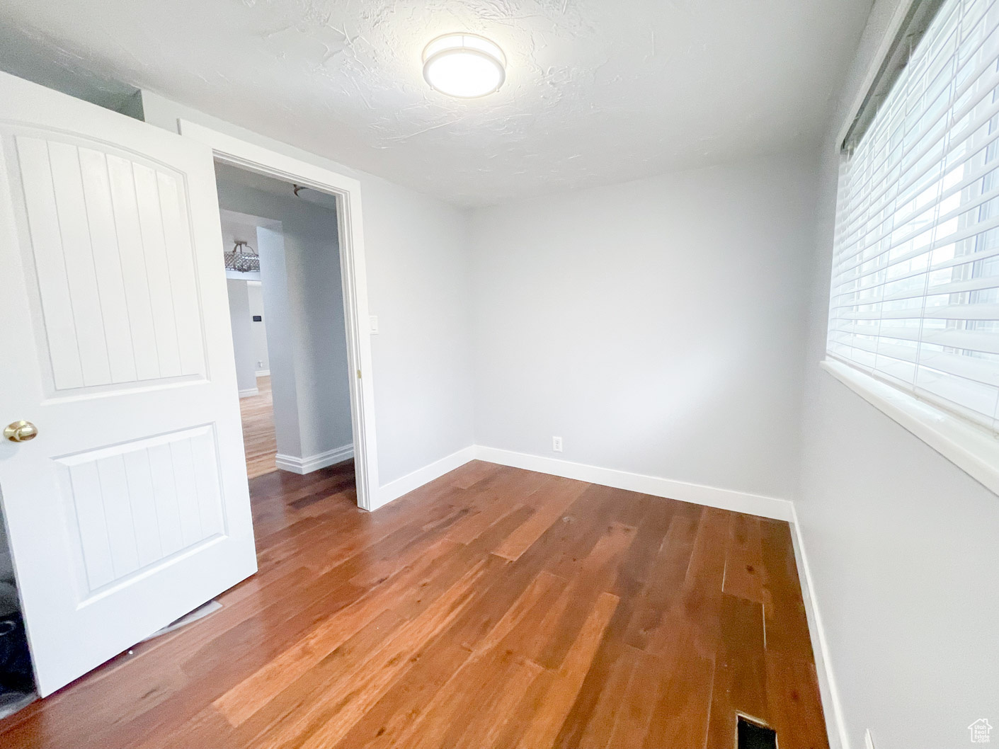 Empty room featuring wood-type flooring and a textured ceiling