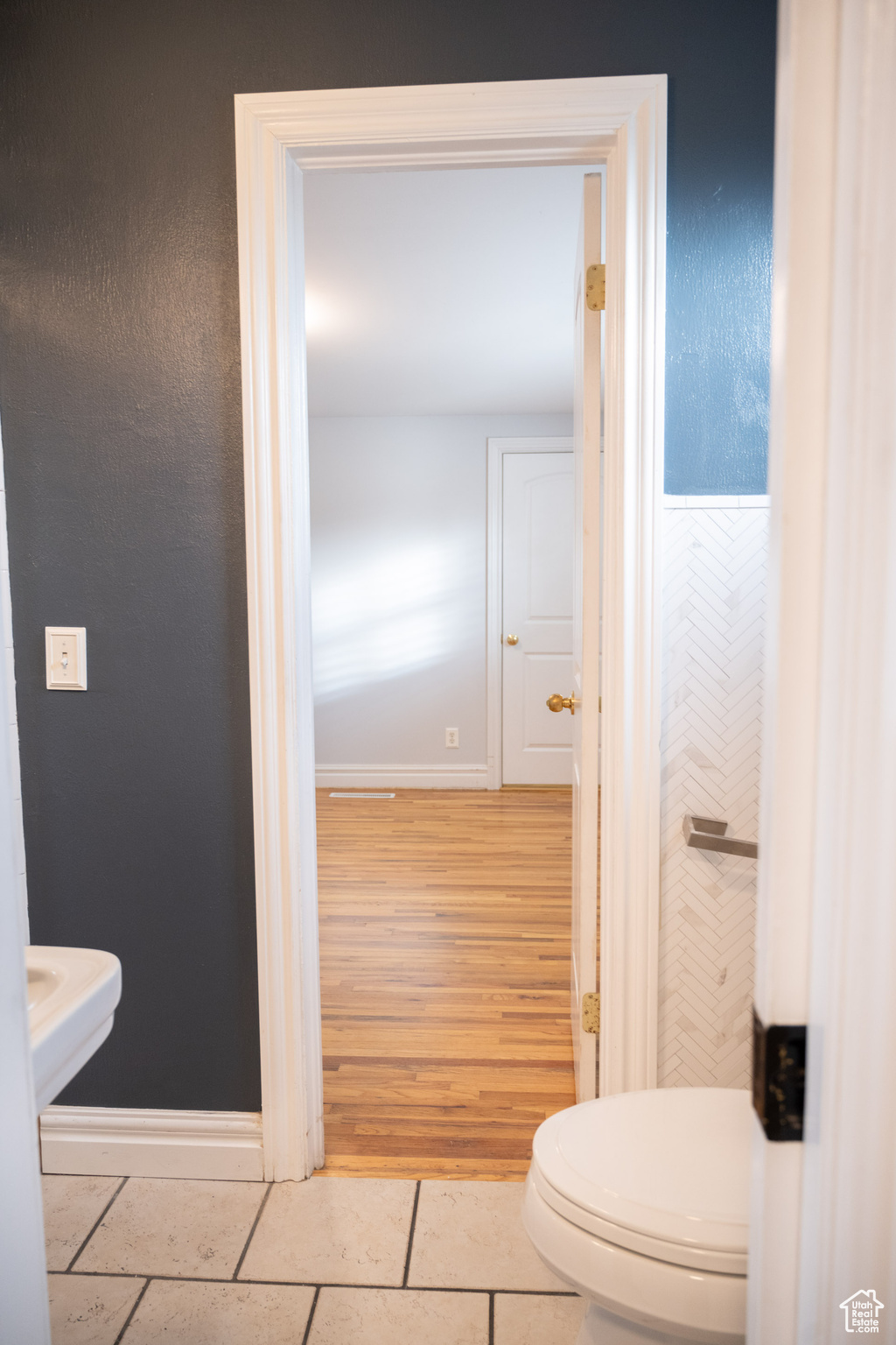 Bathroom with hardwood / wood-style flooring and toilet