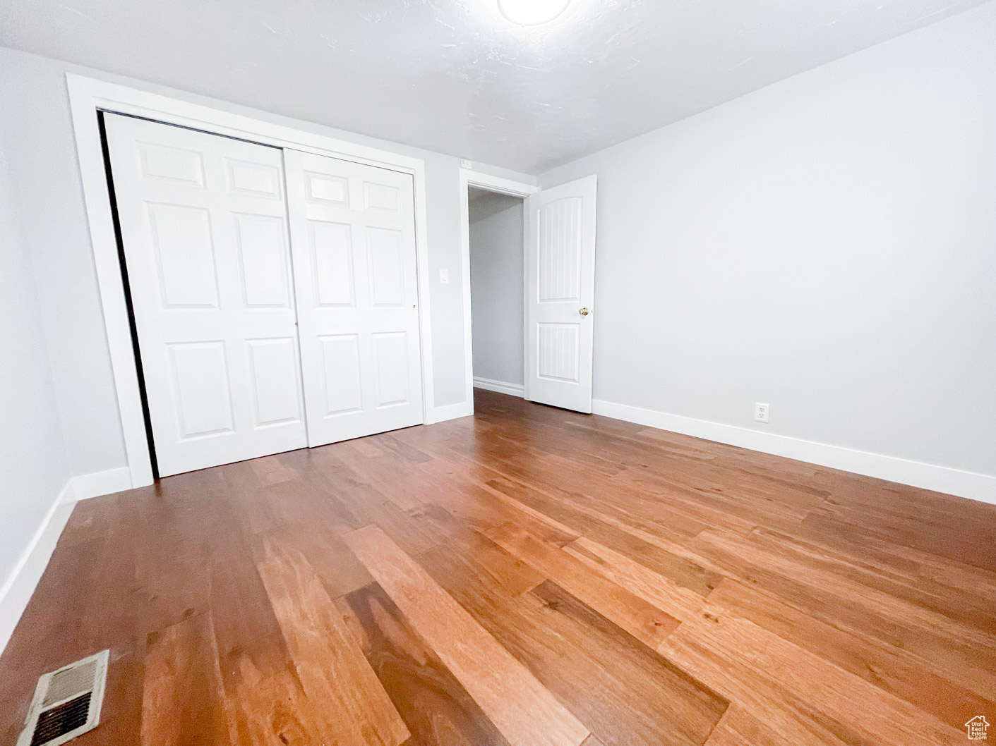 Main Unfurnished bedroom with a closet and wood-type flooring