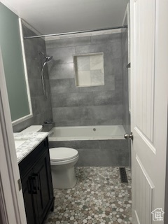 Full bathroom featuring tile patterned floors, vanity, toilet, and tiled shower / bath combo