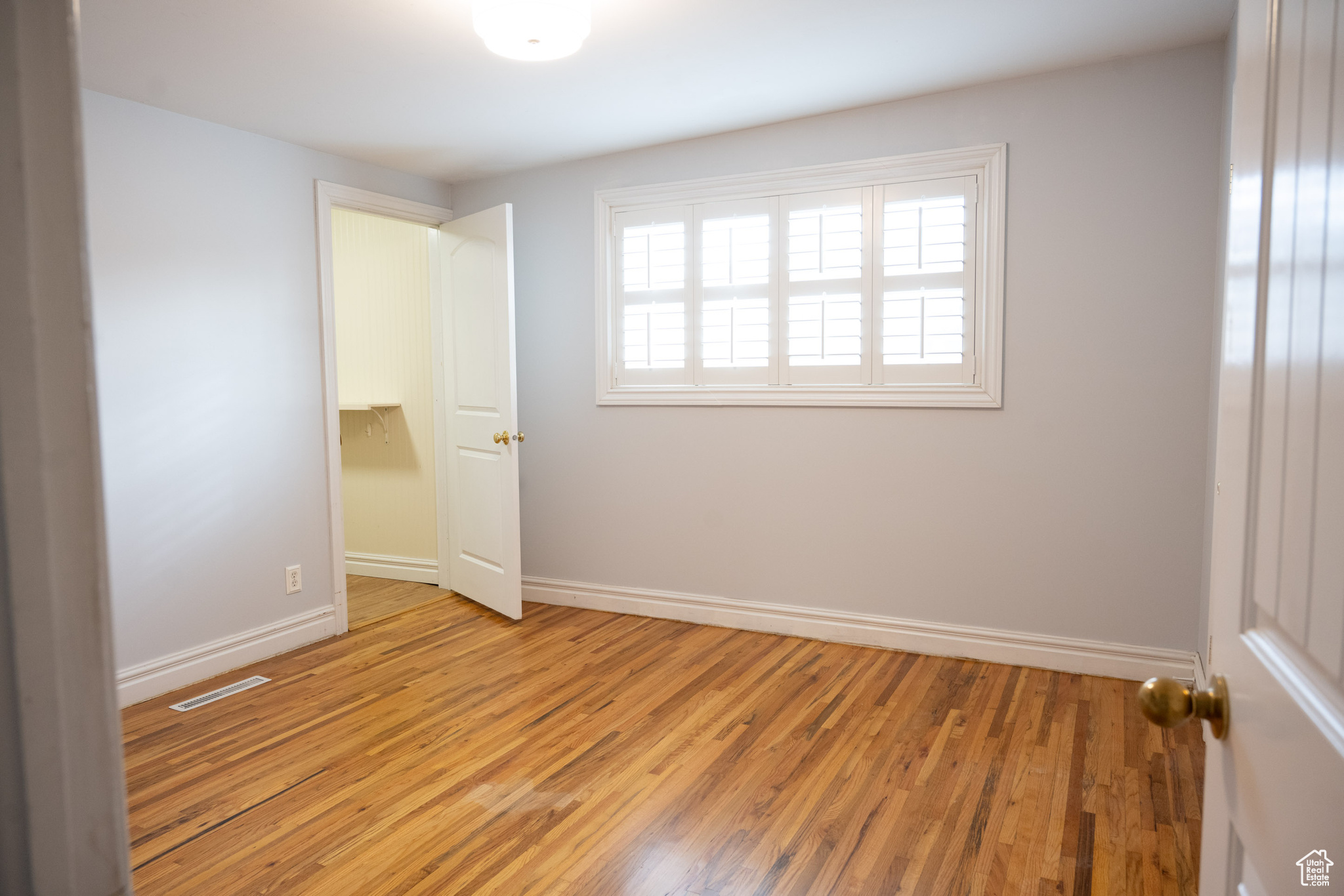 Empty room with light hardwood / wood-style floors