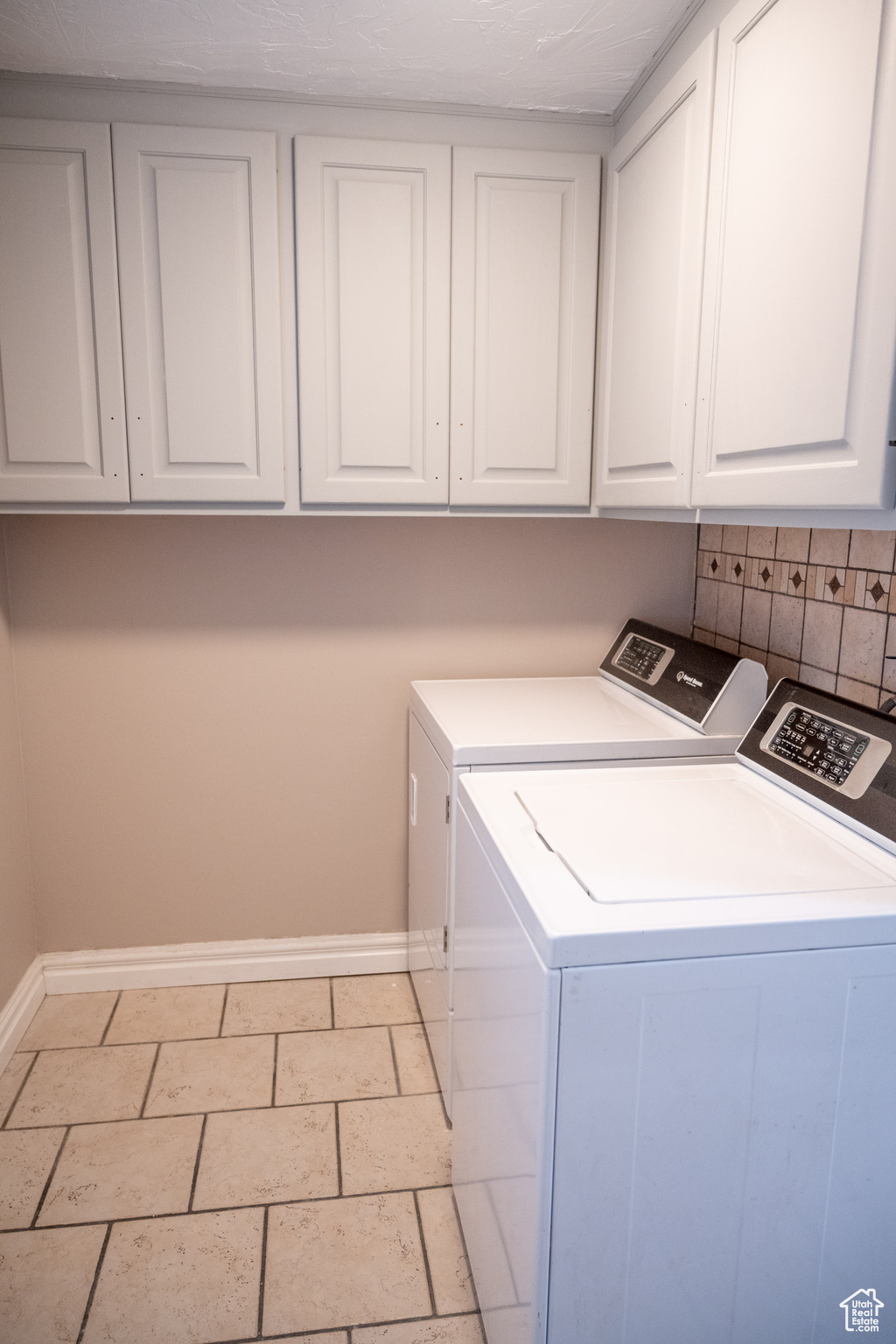 Washroom with cabinets and washing machine and clothes dryer