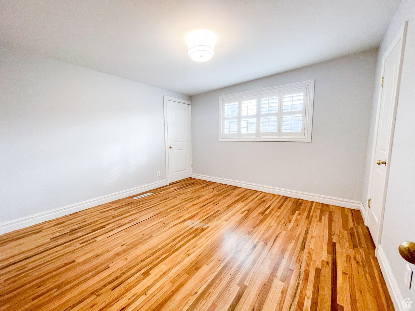 Empty room with light hardwood / wood-style flooring