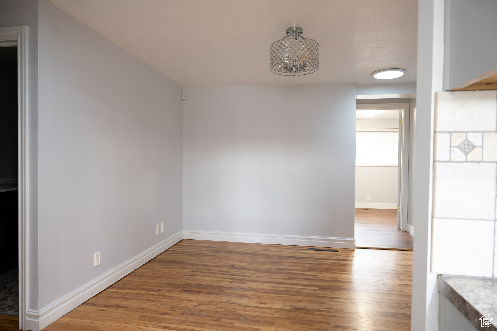 Unfurnished dining area with hardwood / wood-style floors and a notable chandelier