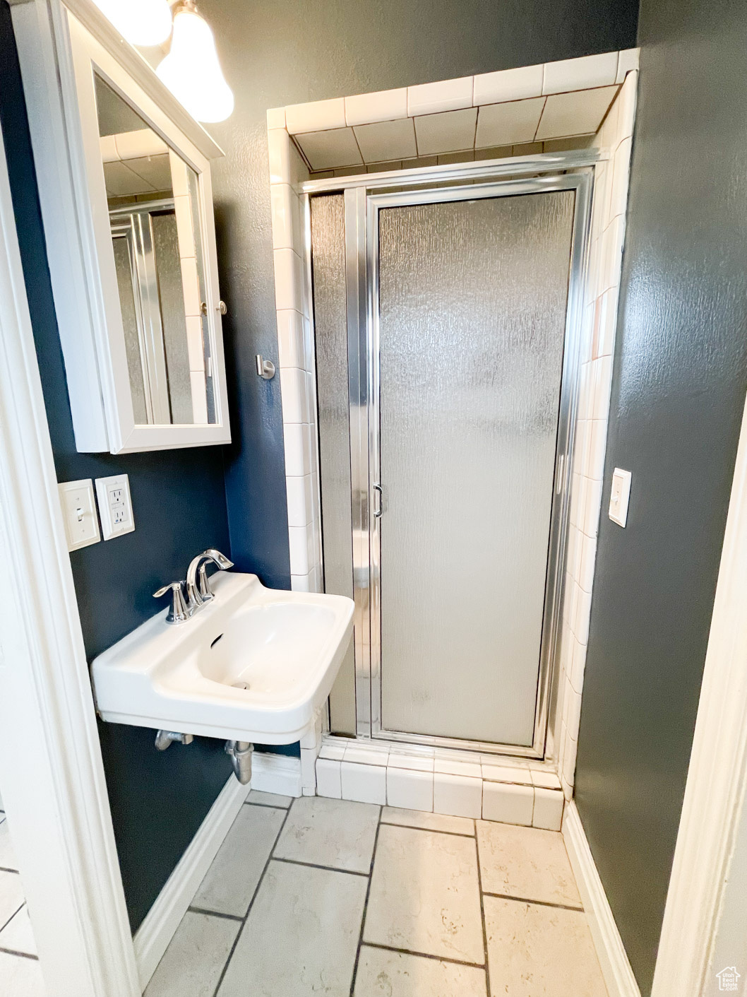 Bathroom featuring tile patterned floors, walk in shower, and sink for main bedroom