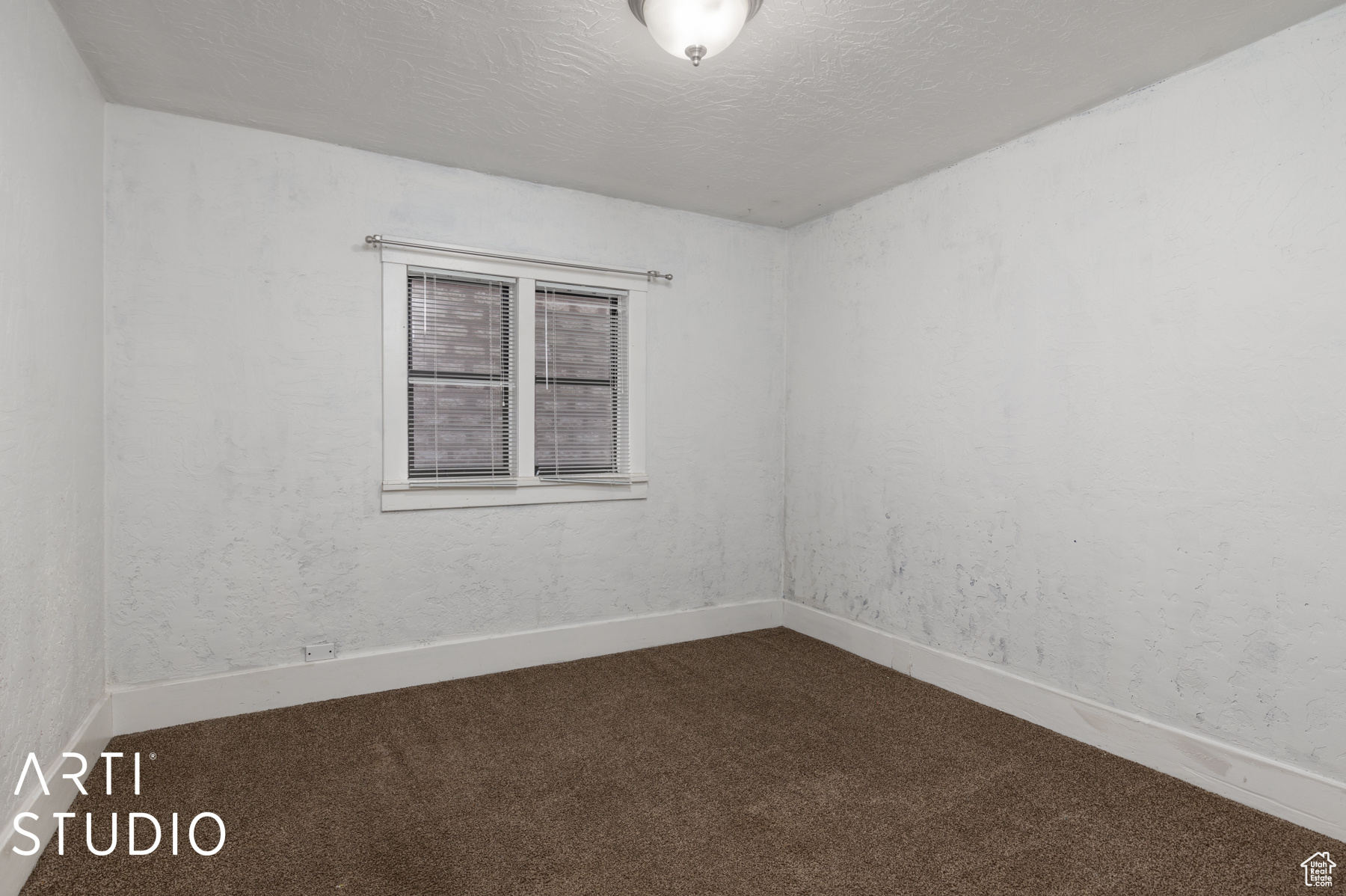 Carpeted spare room with a textured ceiling