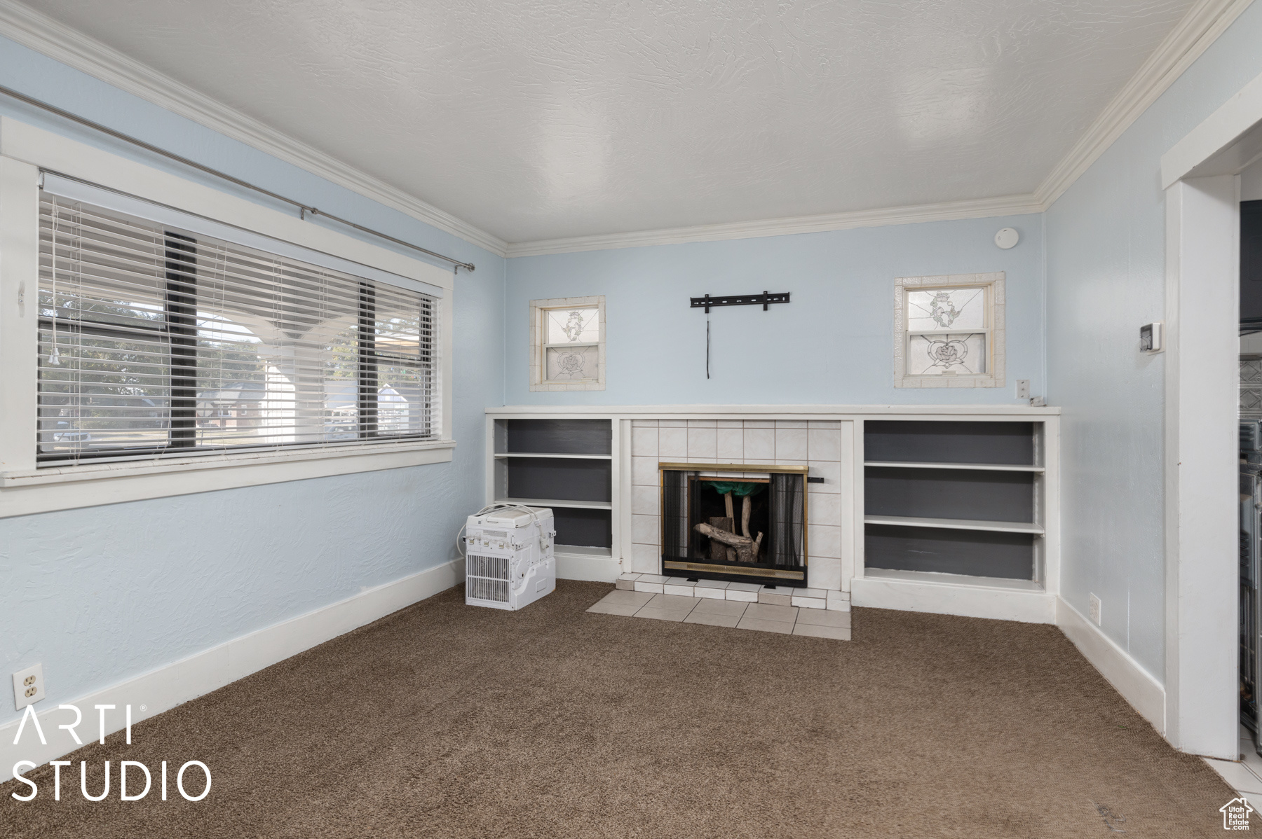 Unfurnished living room with a fireplace, carpet floors, and a healthy amount of sunlight