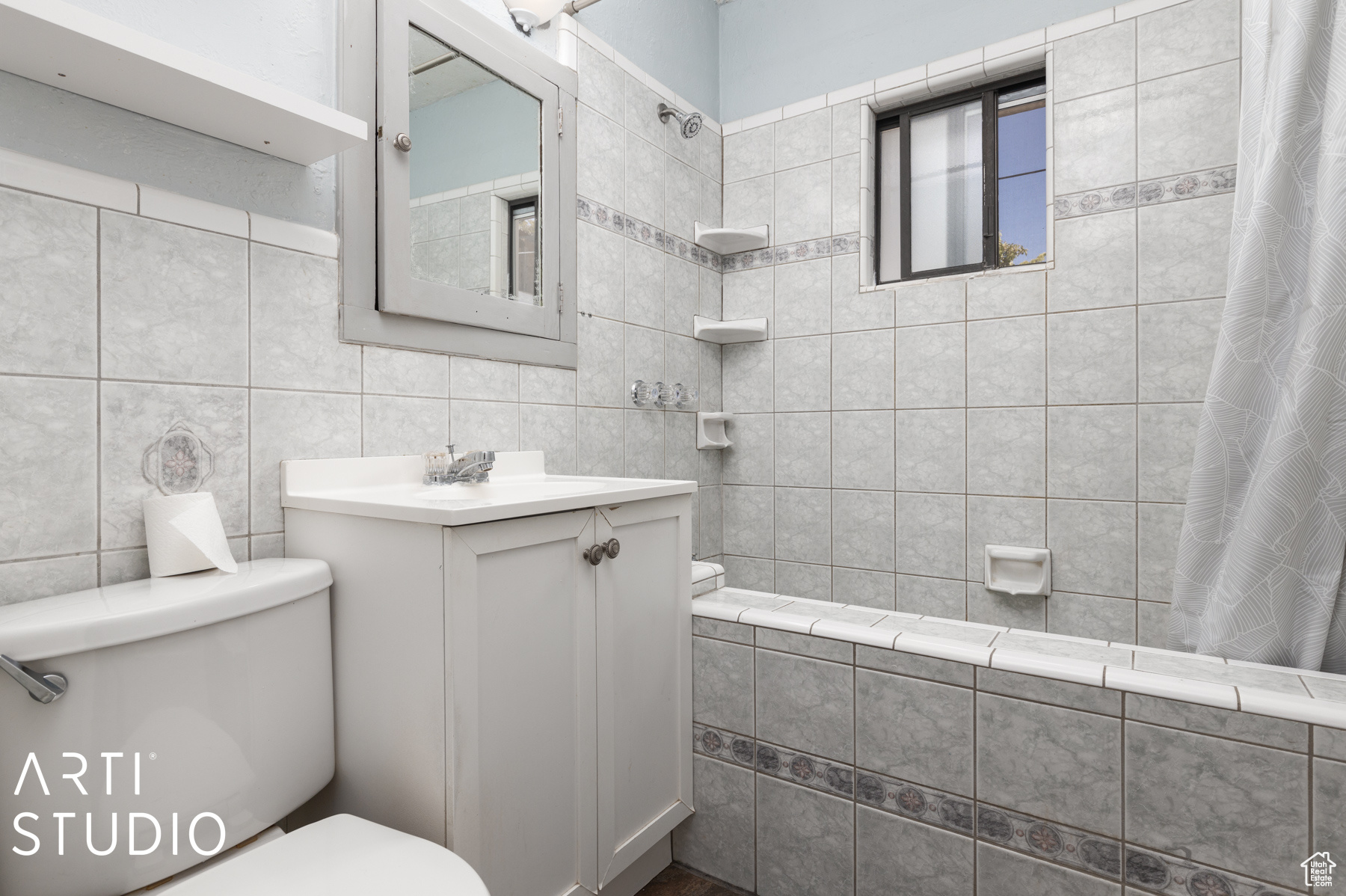 Full bathroom with shower / bath combo, vanity, toilet, and tile walls